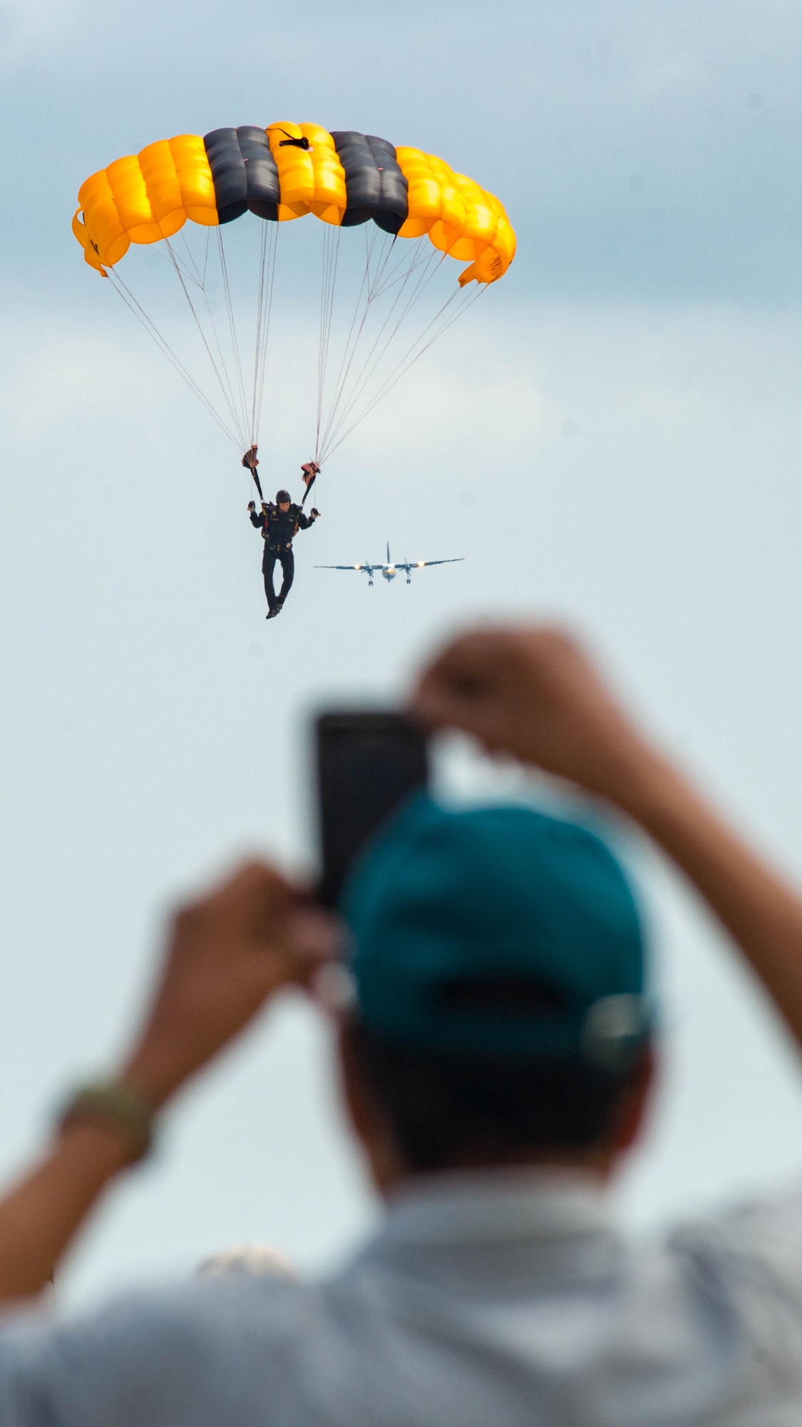 Spectators watch as a U.S. Army Golden Knights parachute team member prepares to land during the AirPower Over Hampton Roads JBLE Air and Space Expo at Joint Base Langley-Eustis, Virginia, May 20, 2018.