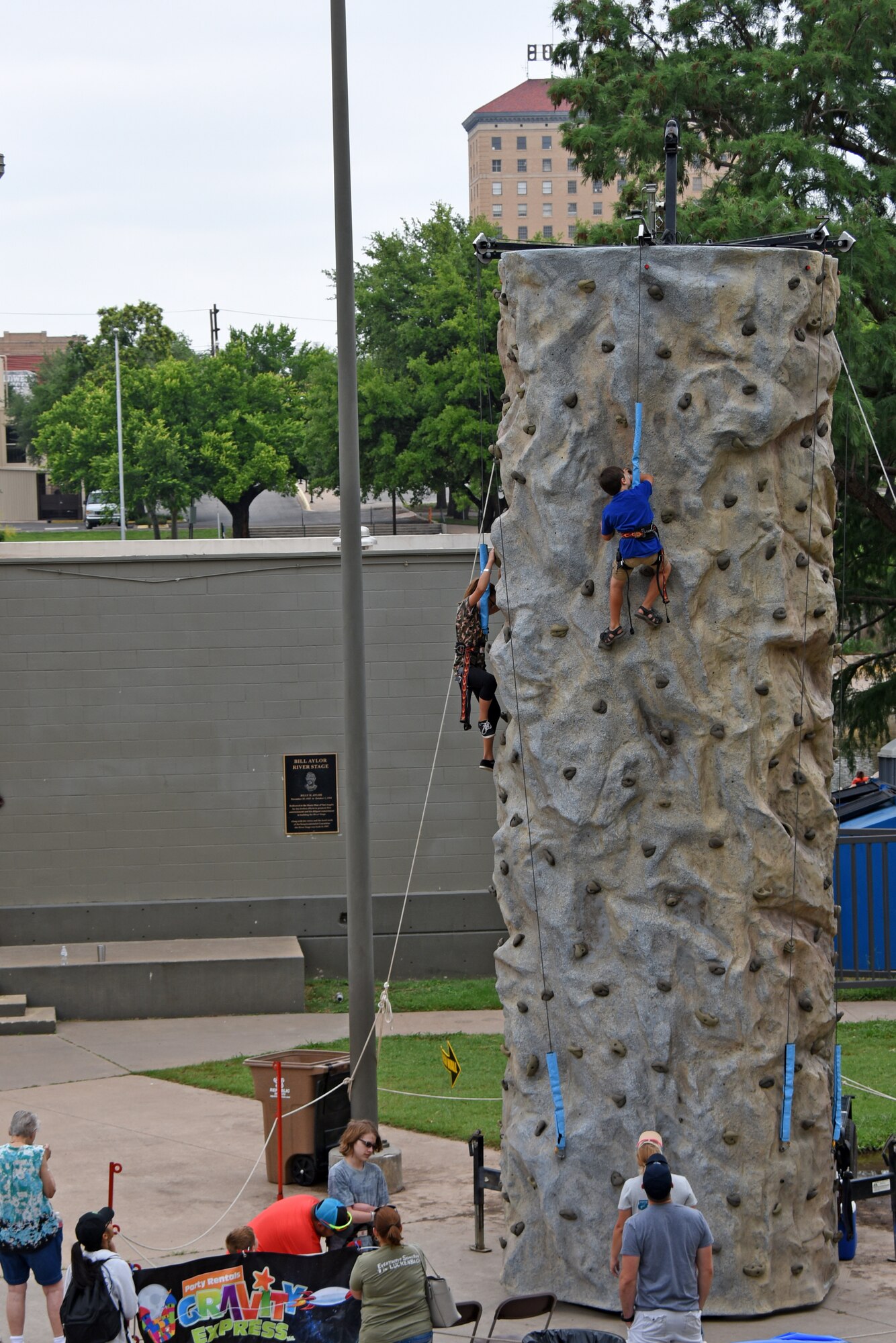 Participants climb a rock wall set up at the Bill Aylor Sr. Memorial RiverStage in San Angelo, Texas, May 19, 2018. The rock wall was just one of many free events during Goodfellow Appreciation Day allowing San Angelo a way to show military members and their families that the community appreciates their service and sacrifices. (U.S. Air Force photo by Airman 1st Class Zachary Chapman/Released)