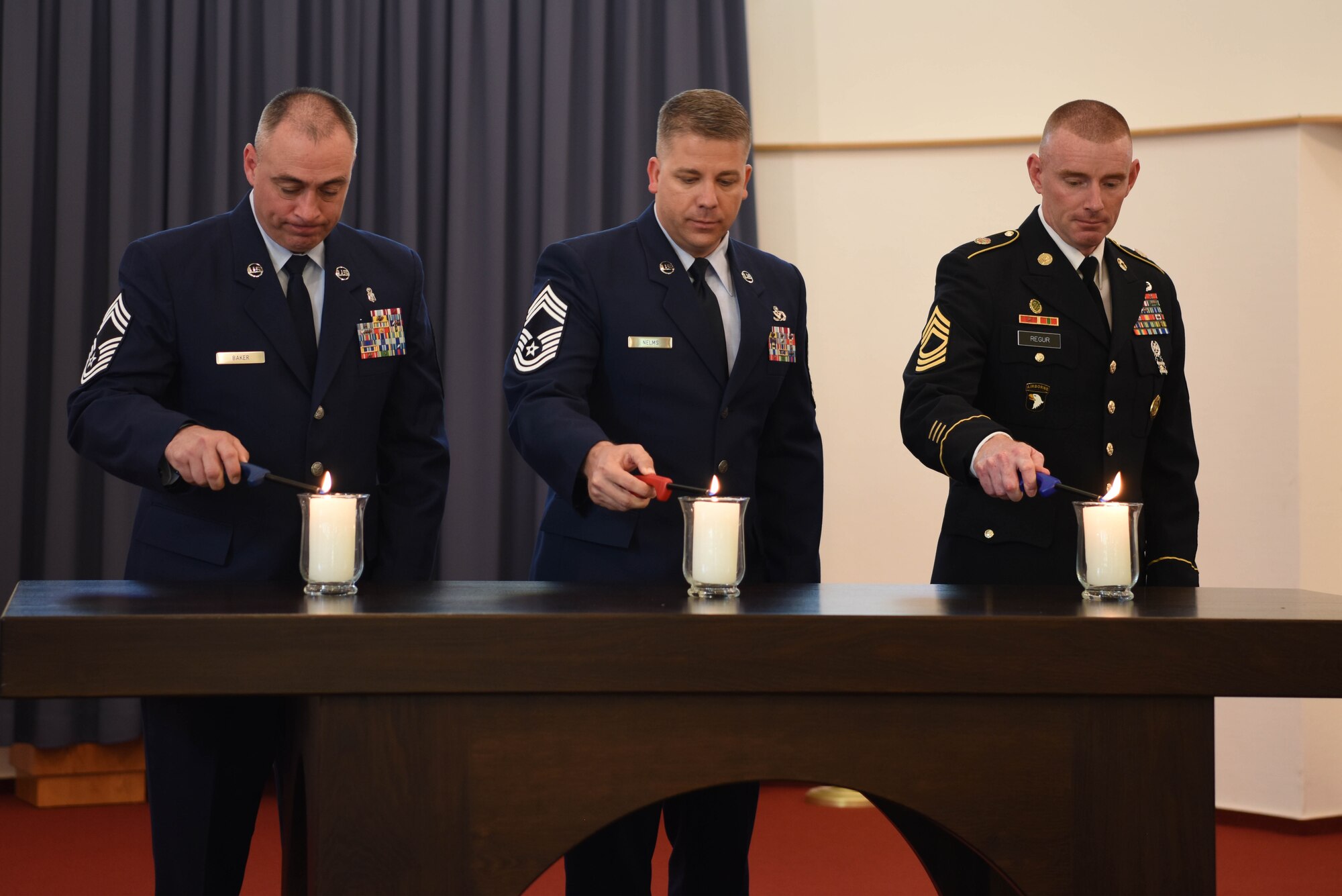 Members of the Ramstein Area Chief’s Group light candles during Kindergraves Memorial at Daenner Kaserne Chapel in Kaiserslautern, Germany, May 19, 2018. The Chief’s group is one of the organizations responsible for the up-keep of the gravesite.