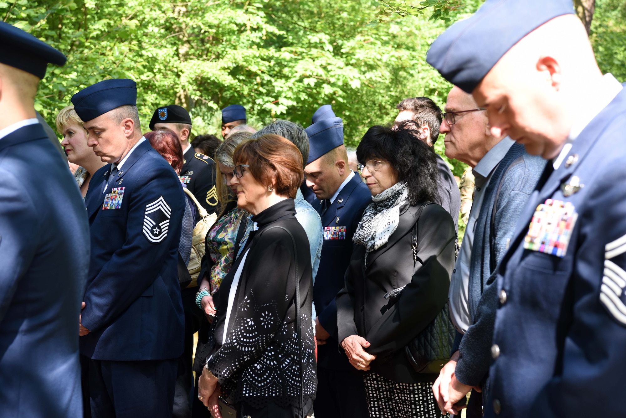 Civilians and military members bow their heads for prayer during the Kindergraves Memorial at Kaiserslautern Main Cemetery May 19, 2018. Participants prayed individually after being led in prayer by two different chaplains.