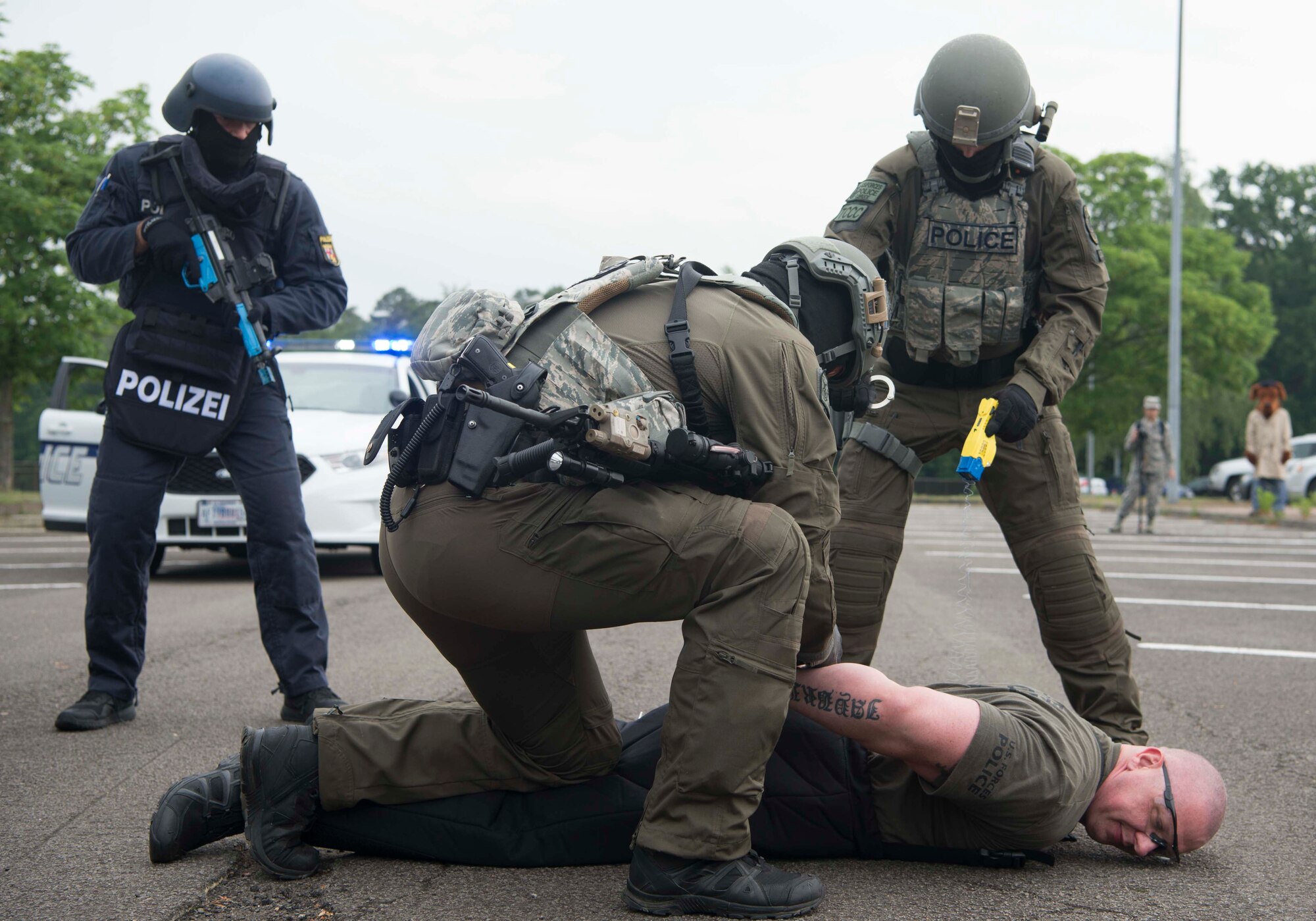 A German Polizei member, left, and two 569th U.S. Forces Police Squadron Zivilpolizei members demonstrate restraining an individual during Police Week 2018 on Ramstein Air Base, Germany, May 14, 2018. The demonstration displayed the cooperation and capabilities between Polizei and the 569th USFPS.