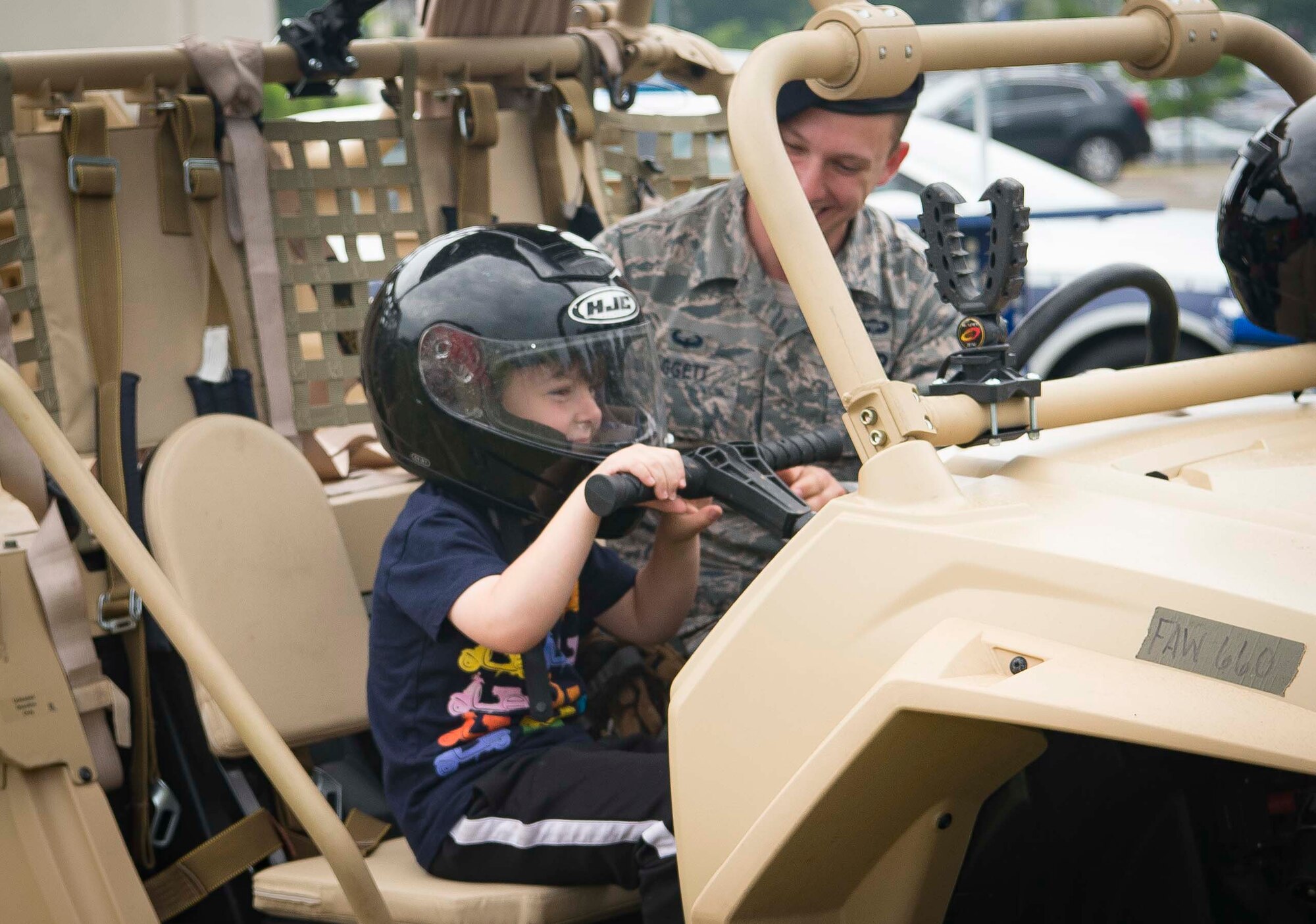 U.S. Air Force Senior Airman Ryan Daggett, 435th Security Forces Squadron contingency response team member, allows a child to sit in a Razor all-terrain vehicle during Police Week 2018 on Ramstein Air Base, Germany, May 14, 2018. The Police Week events were held to involve the entire community, build relationships with the general public, and raise money to go towards organizations that support those law enforcement officers who paid the ultimate sacrifice or survived from a traumatic experience. (U.S. Air Force photo by Senior Airman Elizabeth Baker)