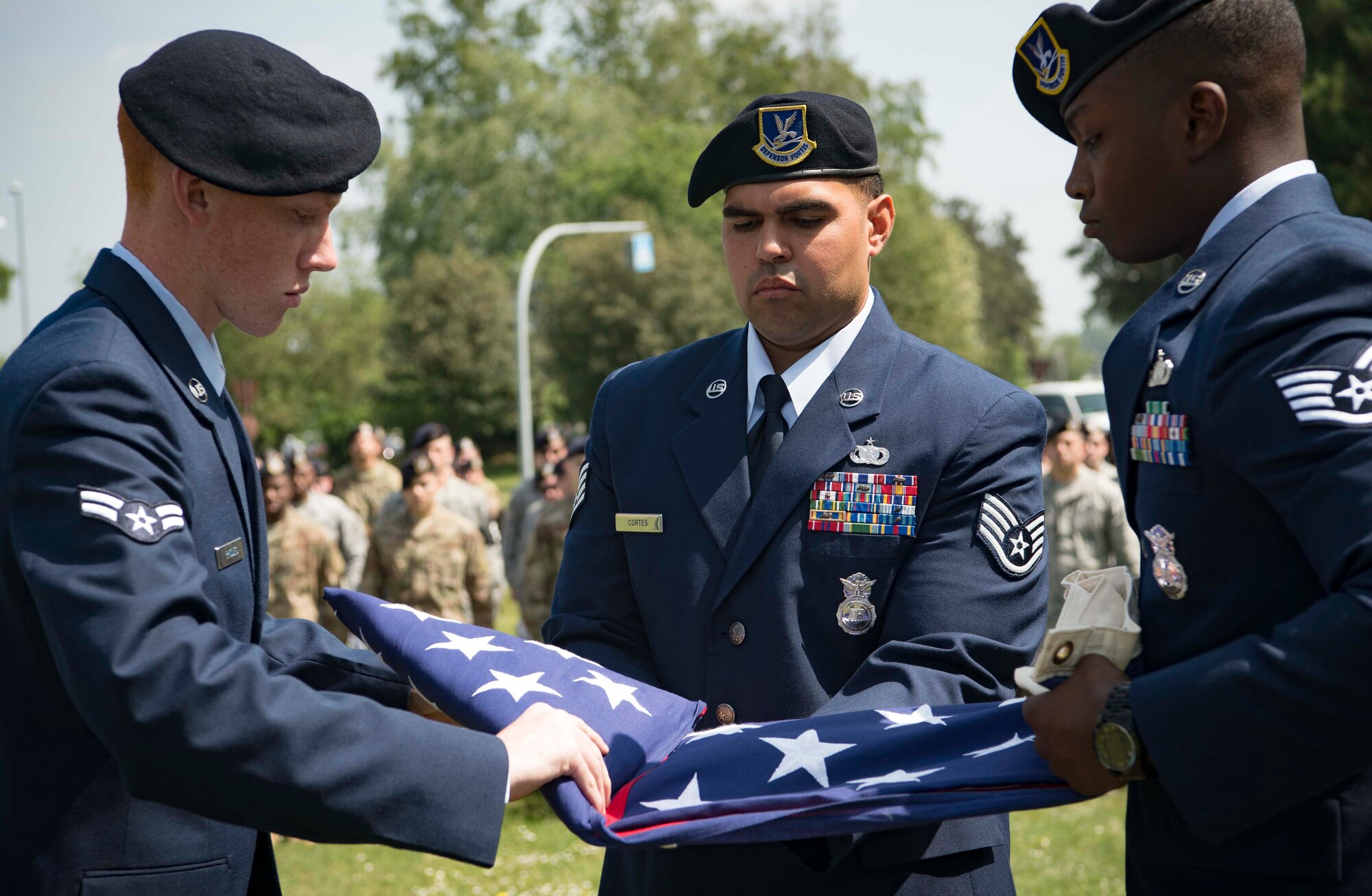 U.S. Airmen fold an American flag in recognition of fallen U.S. armed forces police services members during a Police Week 2018 retreat ceremony on Vogelweh Air Station, Germany, May 18, 2018. Airmen retired the flag according to yearly tradition, wherein they put the flag to rest to represent fallen police services personnel who have also been laid to rest. (U.S. Air Forces photo by Senior Airman Elizabeth Baker)