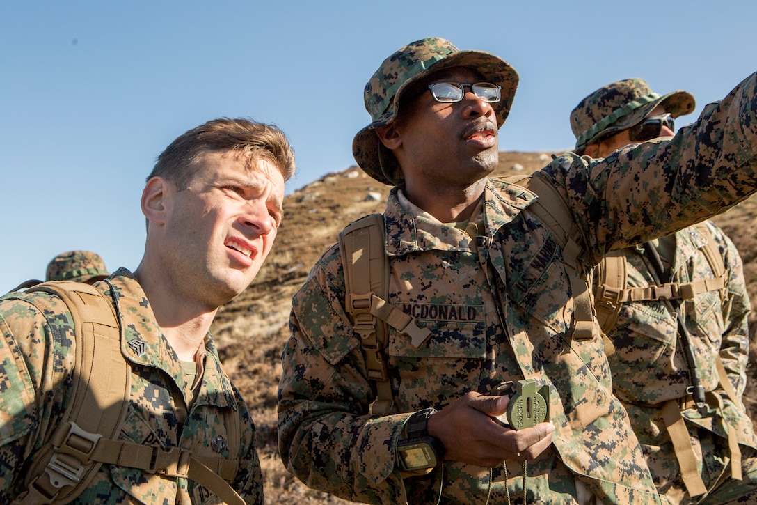 Sgt. Michael Peers (left), a firepower control team chief with 4th Air Naval Gunfire Liaison Company, Force Headquarters Group, and Lance Cpl. Gregory McDonald (right), a radio operator with 4th ANGLICO, FHG, discuss a projected route during a land navigation exercise in Durness, Scotland, April 30, 2018.