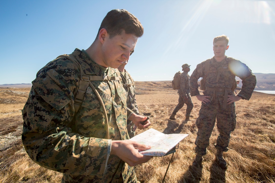 Cpl. Esteban Gonzalez (left), a radio operator with 4th Air Naval Gunfire Liaison Company, Force Headquarters Group, checks his grid coordinates for the location of the final checkpoint during a land navigation course in Durness, Scotland, April 30, 2018.