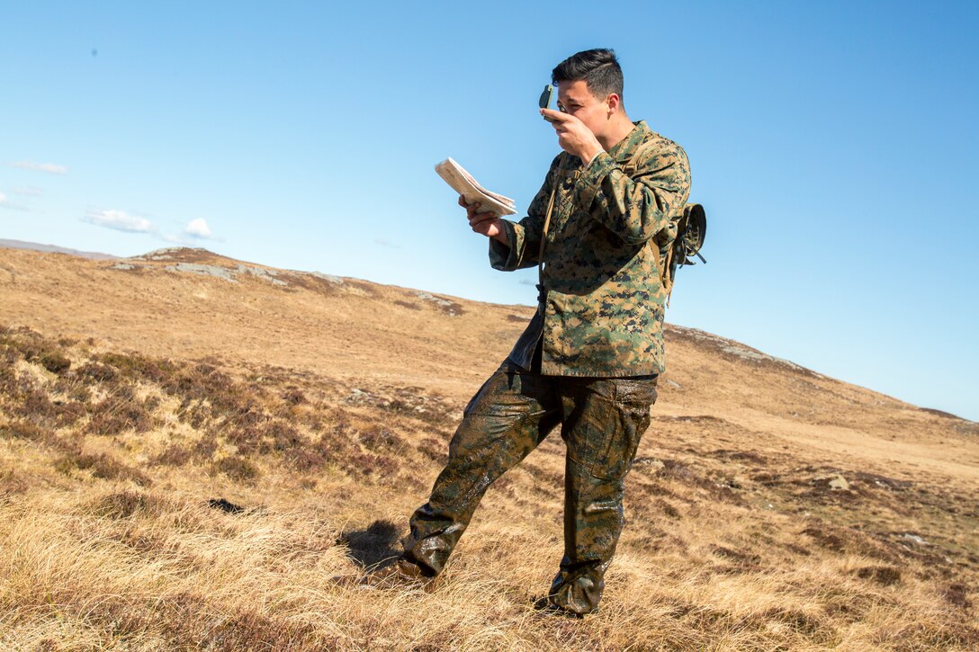 Cpl. Esteban Gonzalez, a radio operator with 4th Air Naval Gunfire Liaison Company, Force Headquarters Group, uses his compass to read the course baring (azimuth) for the final checkpoint during a land navigation exercise in Durness, Scotland, April 30, 2018.