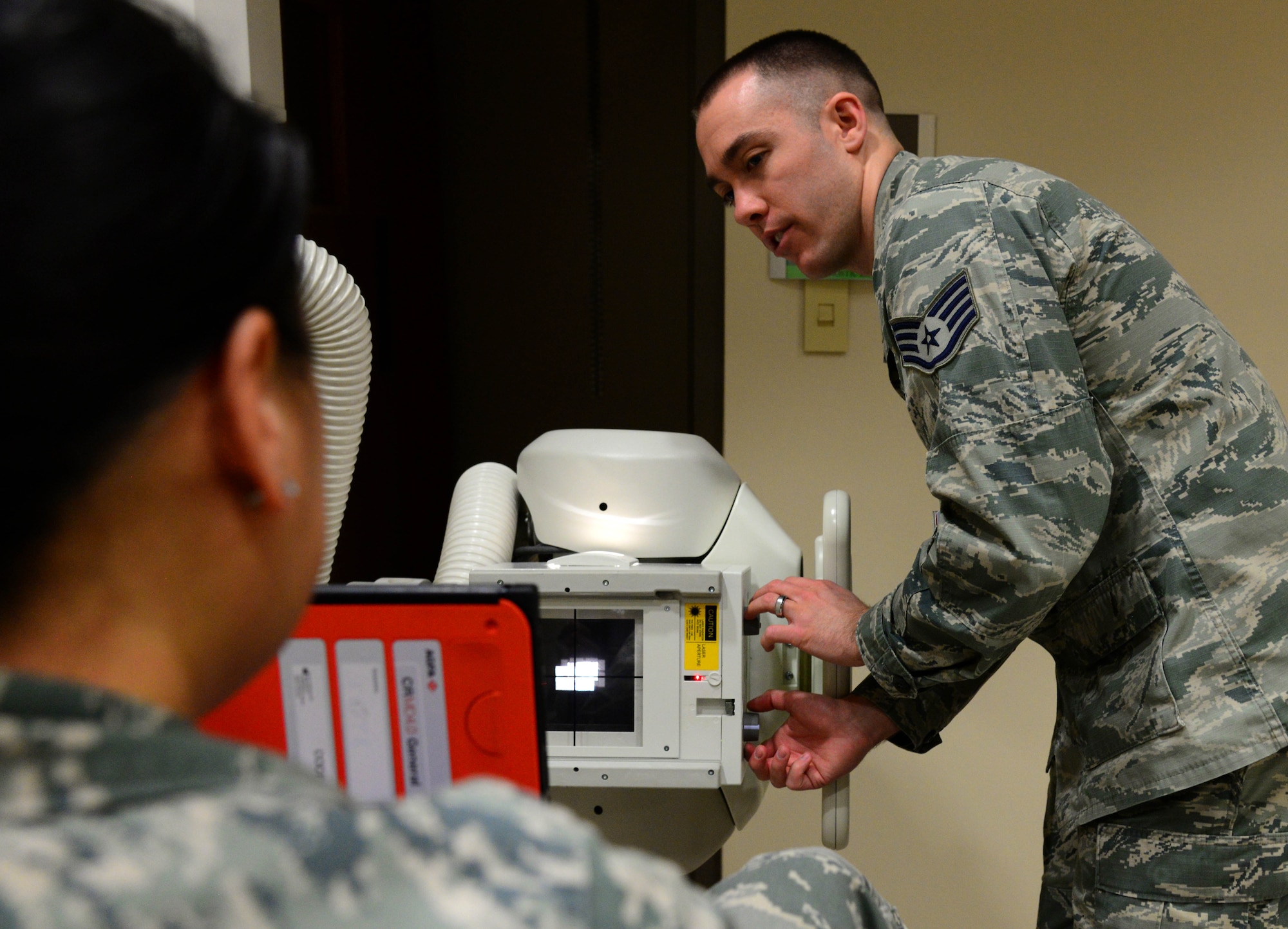 Staff Sgt. Ryan Gulland, a 28th Medical Support Squadron diagnostic imaging technician, captures a “sunrise” X-ray image of Master Sgt. Mia Newmeyer, 28th MDSS diagnostic imaging noncommissioned officer in charge, inside the 28th Medical Group at Ellsworth Air Force Base, S.D., May 11, 2018. This X-ray image is captured by positioning the patient with the knees slightly bent and an x-ray cassette placed behind the knee being examined, so the produced image gives the appearance of a sunrise. (U.S. Air Force photo by Senior Airman Denise Jenson)