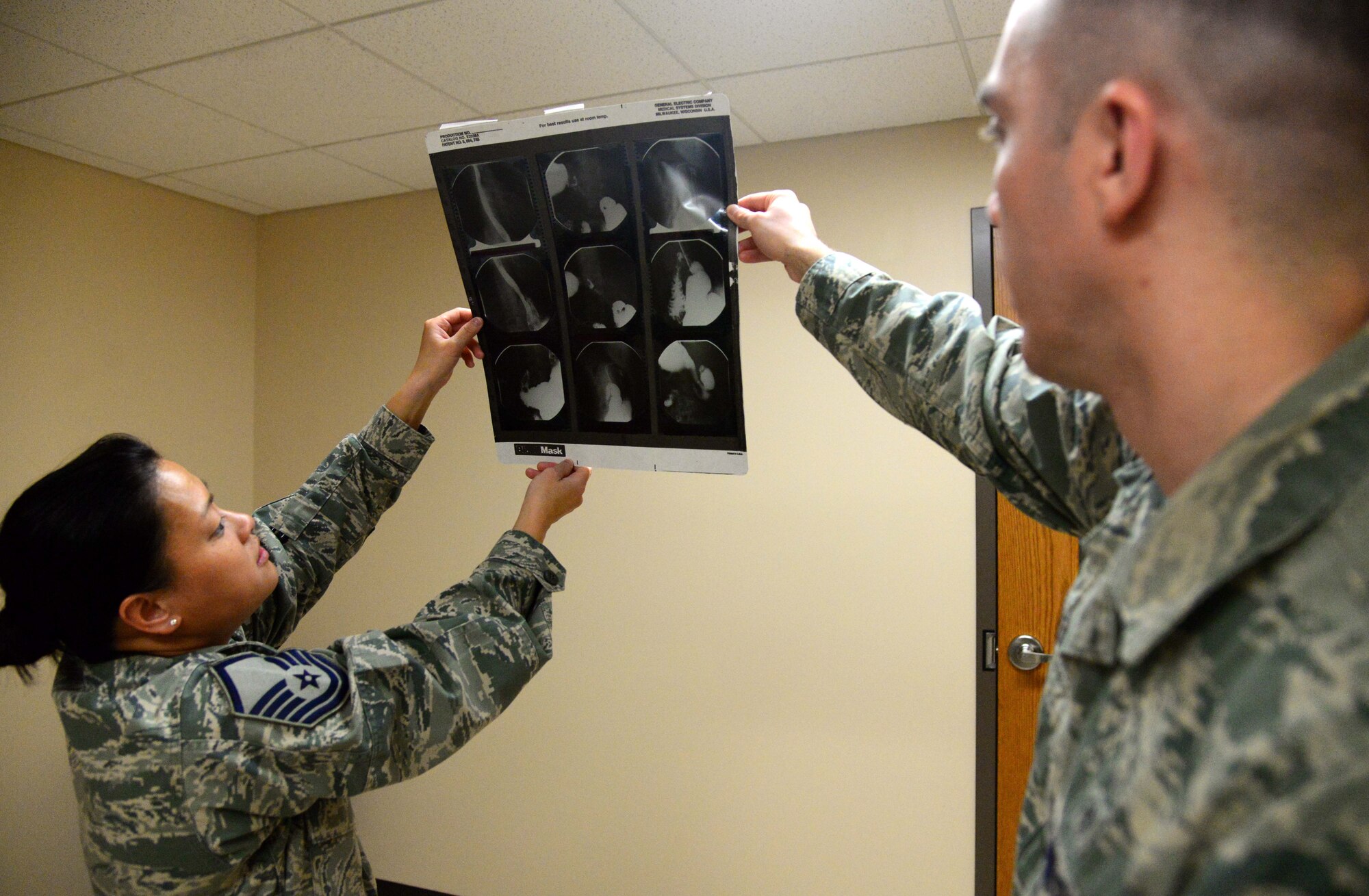 Master Sgt. Mia Newmeyer, 28th Medical Support Squadron diagnostic imaging noncommissioned officer in charge, shows Staff Sgt. Ryan Gulland, a 28th Medical Support Squadron diagnostic imaging technician, an old X-ray during a training session at the 28th Medical Group at Ellsworth Air Force Base, S.D., May 11, 2018. Diagnostic images processed and stored electronically to allow for accurate and expedient review. (U.S. Air Force photo by Senior Airman Denise Jenson)