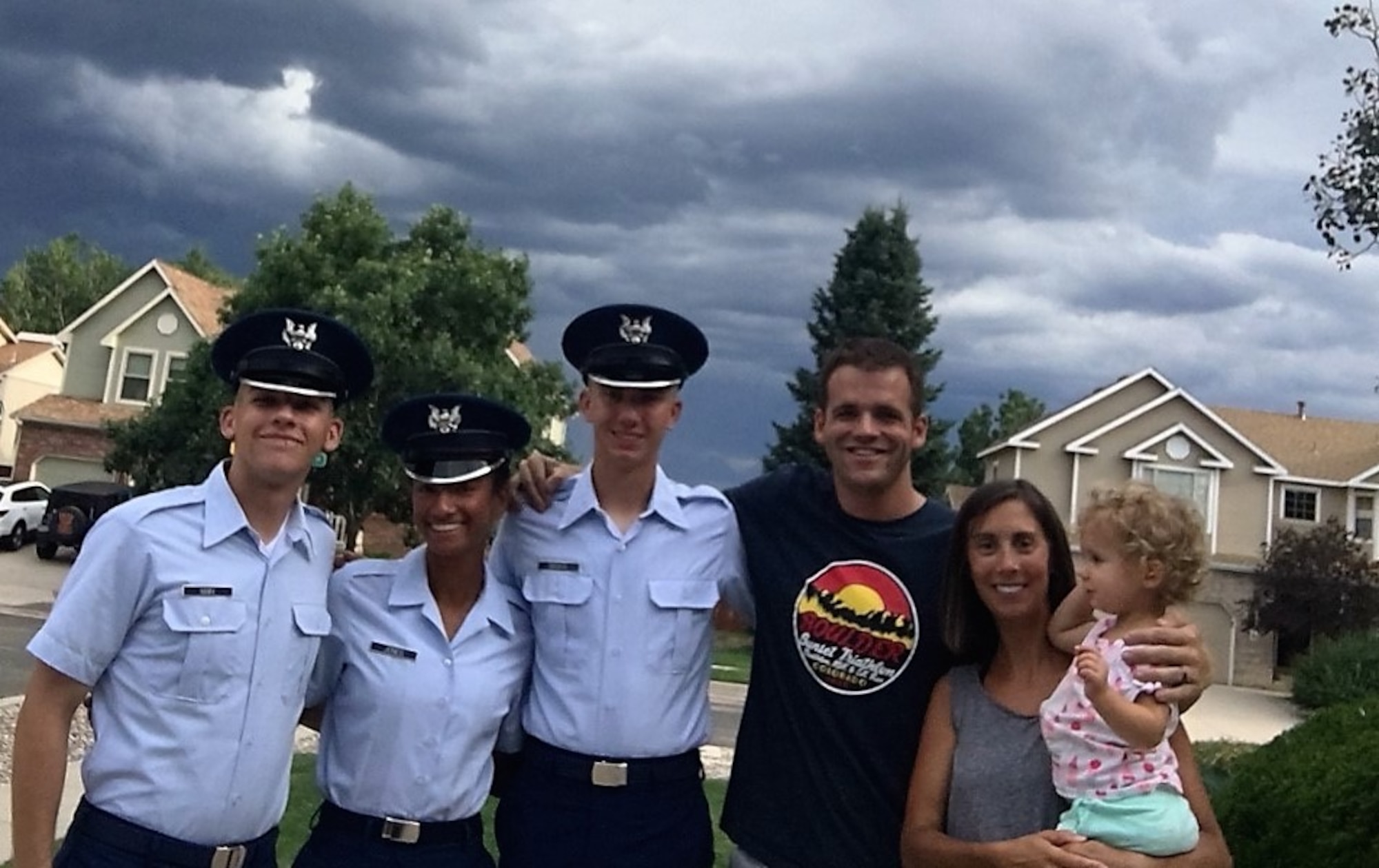 Maj. Sean O’Malley (70th Flying Training Group, and 557th Flying Training Squadron Chief of Pilot Instructor Training), wife Becky and daughter Eliza pose for a family photo with their sponsored cadets after a de-stressing home cooked meal. (U.S. Air Force photo)