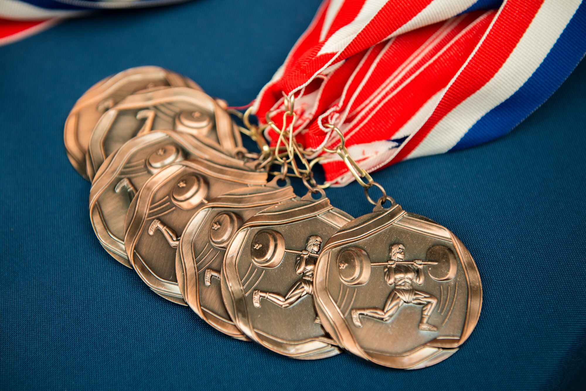 Third place, bronze medals rest on a table during the Luke Air Force Base Powerlifting Competition at Luke AFB, Ariz., May 18, 2018. First through third place medals were awarded to competitors who lifted the most weight and completed the most repetitions for each workout. Powerlift competitor, John Canterberry won the overall competition lifting a total combined weight of 1,500 lbs. (U.S. Air Force photo by Airman 1st Class Alexander Cook)