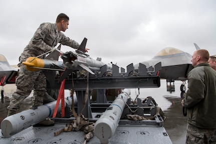 Airman 1st Class Emmanuel Pena, a 525th Aircraft Maintenance Unit weapons loader, readies a munition for loading during the Wing Weapons Load Crew 1st Quarter Competition May 18, 2018, at Joint Base Elmendorf-Richardson, Alaska. The quarterly competition consists of two AMU weapons-section teams going head-to-head for time and accuracy. A weapons load crew is a group of three people responsible for preparing and loading munitions onto an aircraft.