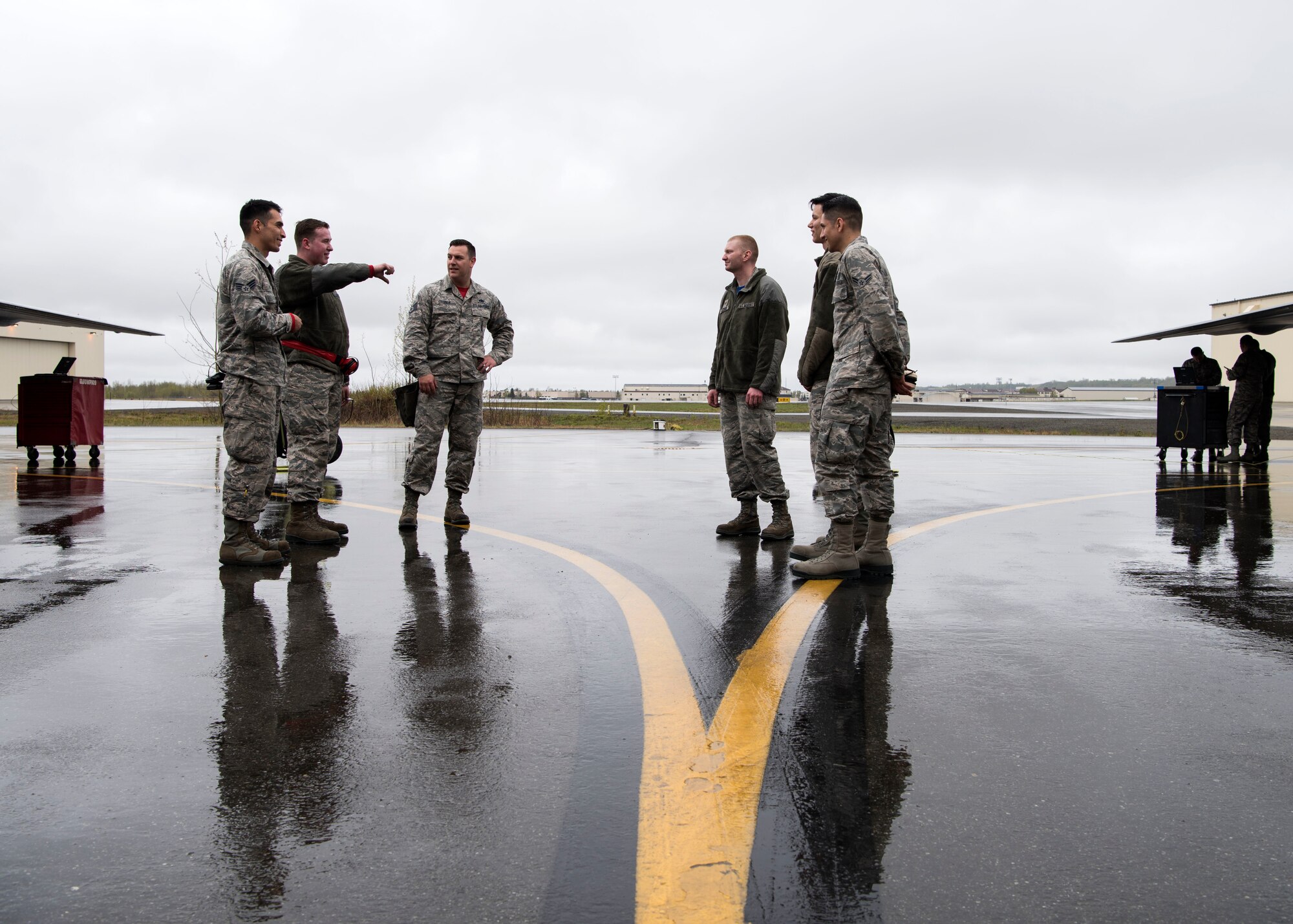 The 90th and 525th aircraft maintenance unit load crew teams stand together as their tools are inspected in front of the two F-22A Raptors used for the Quarterly Wing Weapons Load Crew Competition May 18, 2018, at Joint Base Elmendorf-Richardson, Alaska. The quarterly competition consists of two AMU weapons-section teams going head-to-head for time and accuracy. A weapons load crew is a group of three people responsible for preparing and loading munitions onto an aircraft.