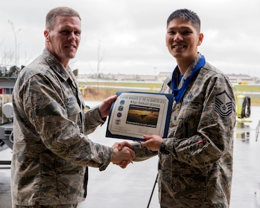 U.S. Air Force Col. Mathew Powell, commander of the 3rd Maintenance Group, presents Master Sgt. Samuel Alonzo with the Weapons Manager of the Quarter award after the Wing Weapons Load Crew 1st Quarter Competition May 18, 2018, at Joint Base Elmendorf-Richardson, Alaska. The quarterly competition consists of two AMU weapons-section teams going head-to-head for time and accuracy.
