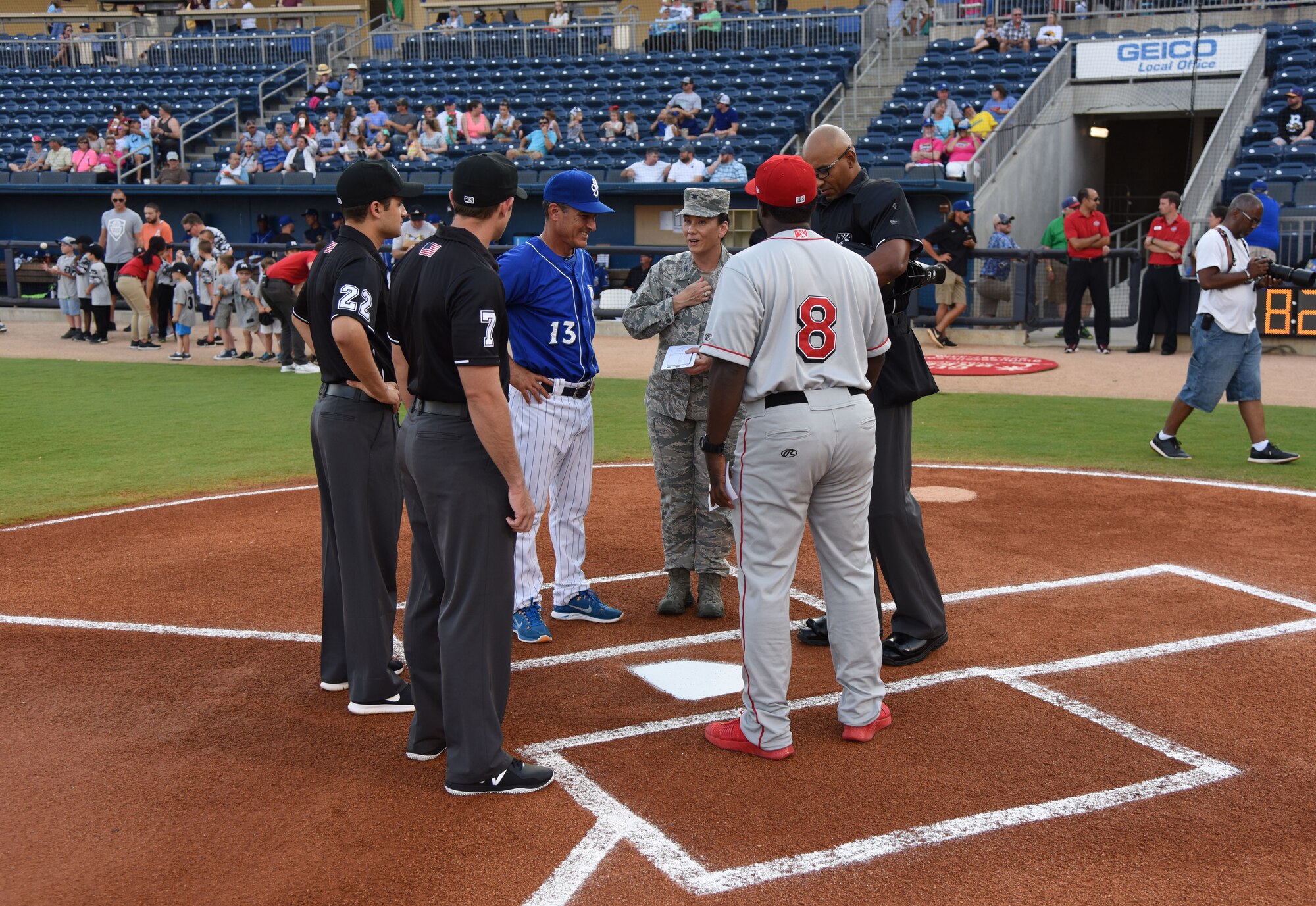Col. Debra A. Lovette, 81st Training Wing commander, joins Mike Guerrero, Biloxi Shuckers manager, at home plate to meet with the umpires and the opposing team’s manager during a Biloxi Shuckers baseball game, in Biloxi, Mississippi, May 17, 2018. Lovette also threw the first pitch during pre-game festivities. (U.S. Air Force photo by Kemberly Groue)