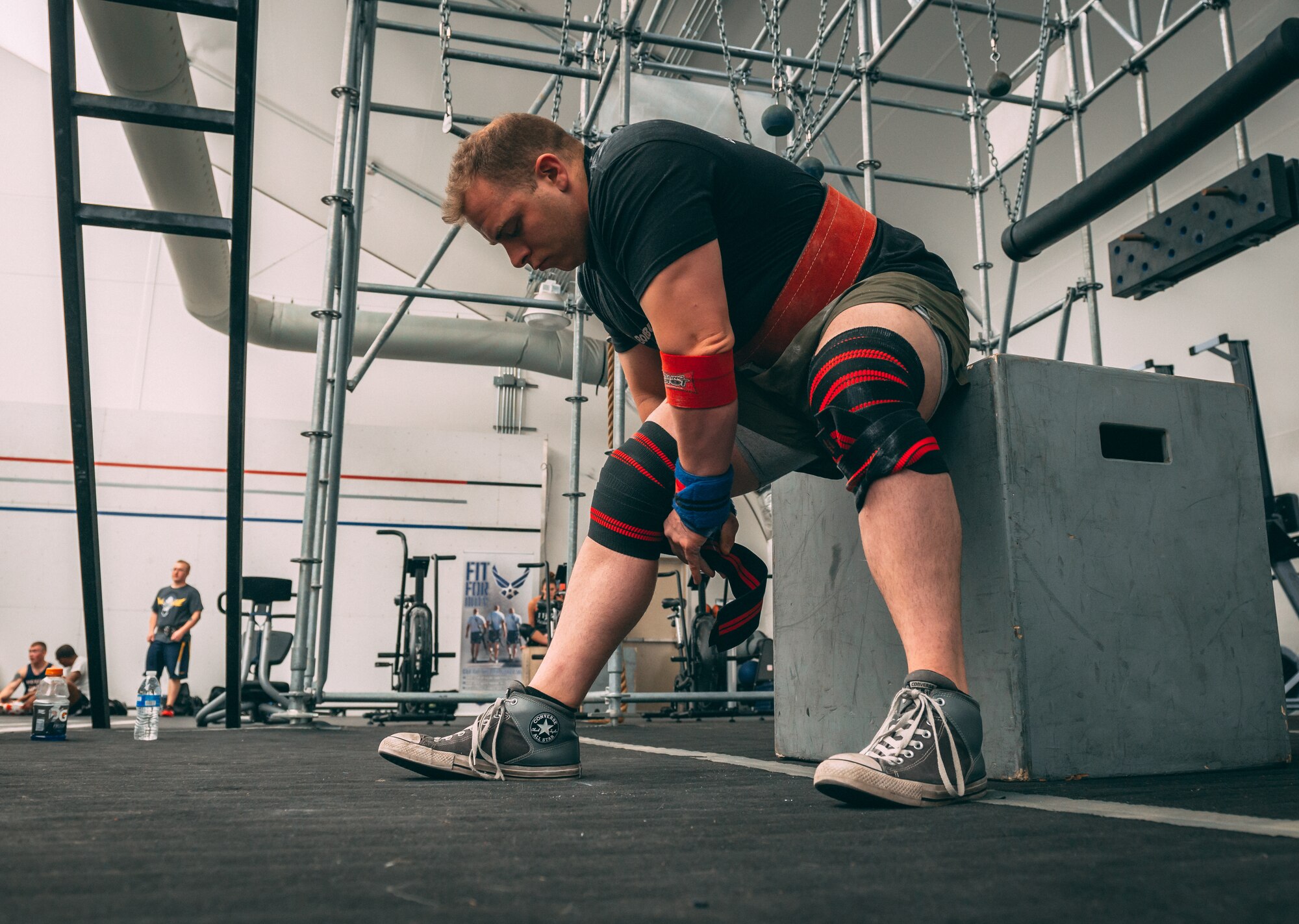 Josh Canterberry, powerlifting competitor, wraps his knee with support wraps before competing in the Luke Air Force Base Powerlifting Competition at Luke AFB, Ariz., May 18, 2018. Sixteen Thunderbolts competed to see who could lift the most weight and complete the highest repetitions of three workouts. (U.S. Air Force photo by Airman 1st Class Alexander Cook)