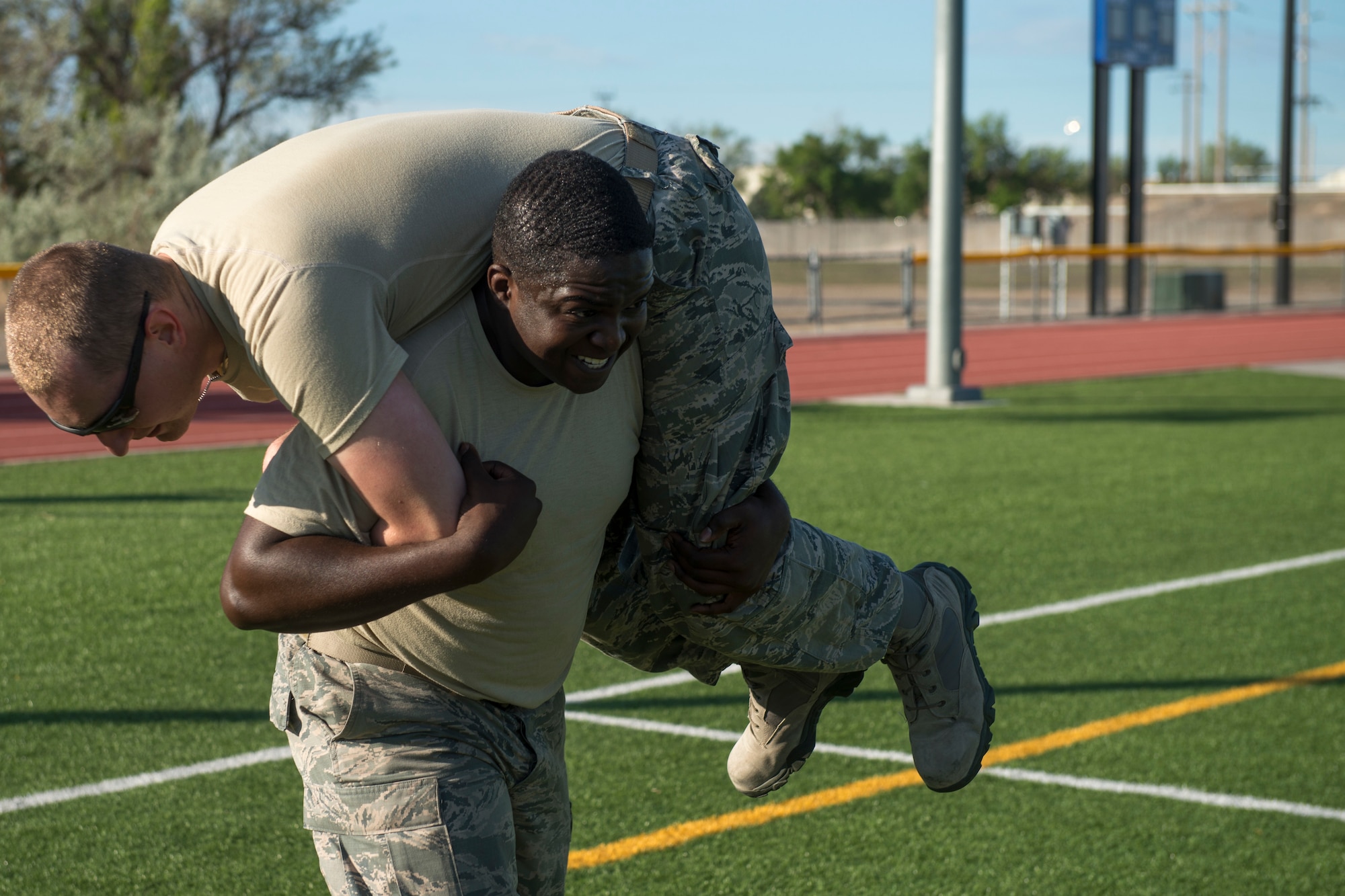 Airman 1st Class Anthony Ford and Senior Airman Steven Waller, 366th Security Forces Squadron response force members, perform a fireman’s carry during the National Police Week memorial workout, May 15, 2018, at Mountain Home Air Force Base, Idaho. The memorial workout included 14 workouts and 14 repetitions to honor the fallen defenders. (U.S. Air Force Photo by Airman 1st Class JaNae Capuno)