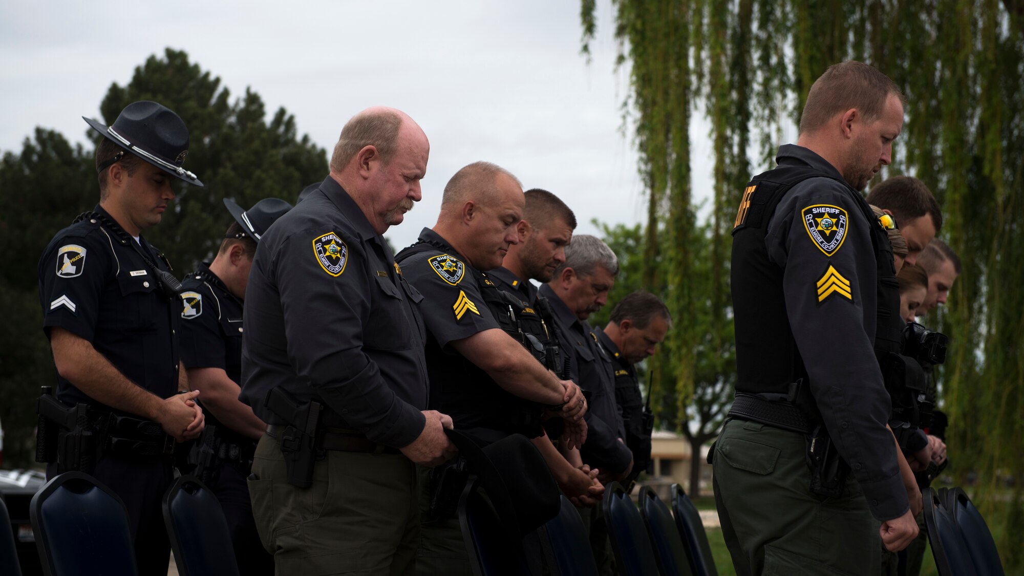 Elmore County law enforcement hold a moment of silence during a final guard mount ceremony, May 18, 2018, at Mountain Home Air Force Base, Idaho. The final guard mount honored law enforcement who have lost their lives in the line of duty and the 14 defenders who have fallen since 9/11. (U.S. Air Force Photo by Airman 1st Class JaNae Capuno)