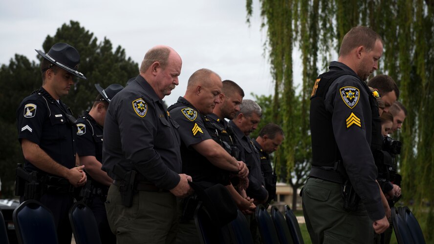 Elmore County law enforcement hold a moment of silence during a final guard mount ceremony, May 18, 2018, at Mountain Home Air Force Base, Idaho. The final guard mount honored law enforcement who have lost their lives in the line of duty and the 14 defenders who have fallen since 9/11. (U.S. Air Force Photo by Airman 1st Class JaNae Capuno)