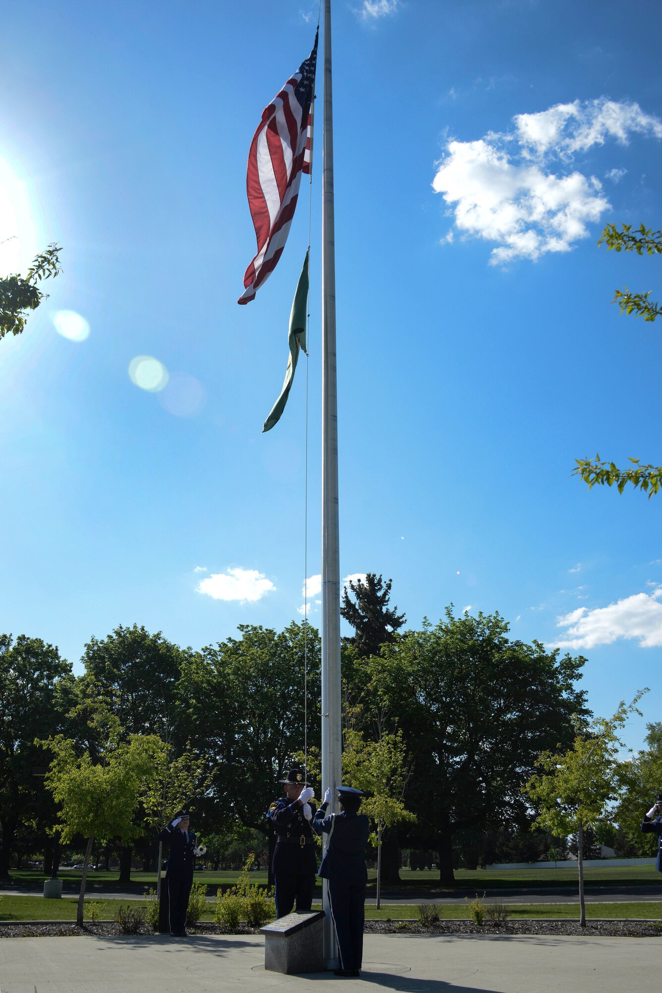 A member of the Fairchild Air Force Base Honor Guard and a law enforcement official lower the flag during a National Police Week Memorial Retreat Ceremony at Fairchild AFB, Washington, May 16, 2018. National Police Week pays recognition to law enforcement officers who lost their lives in the line of duty for the safety and protection of others.