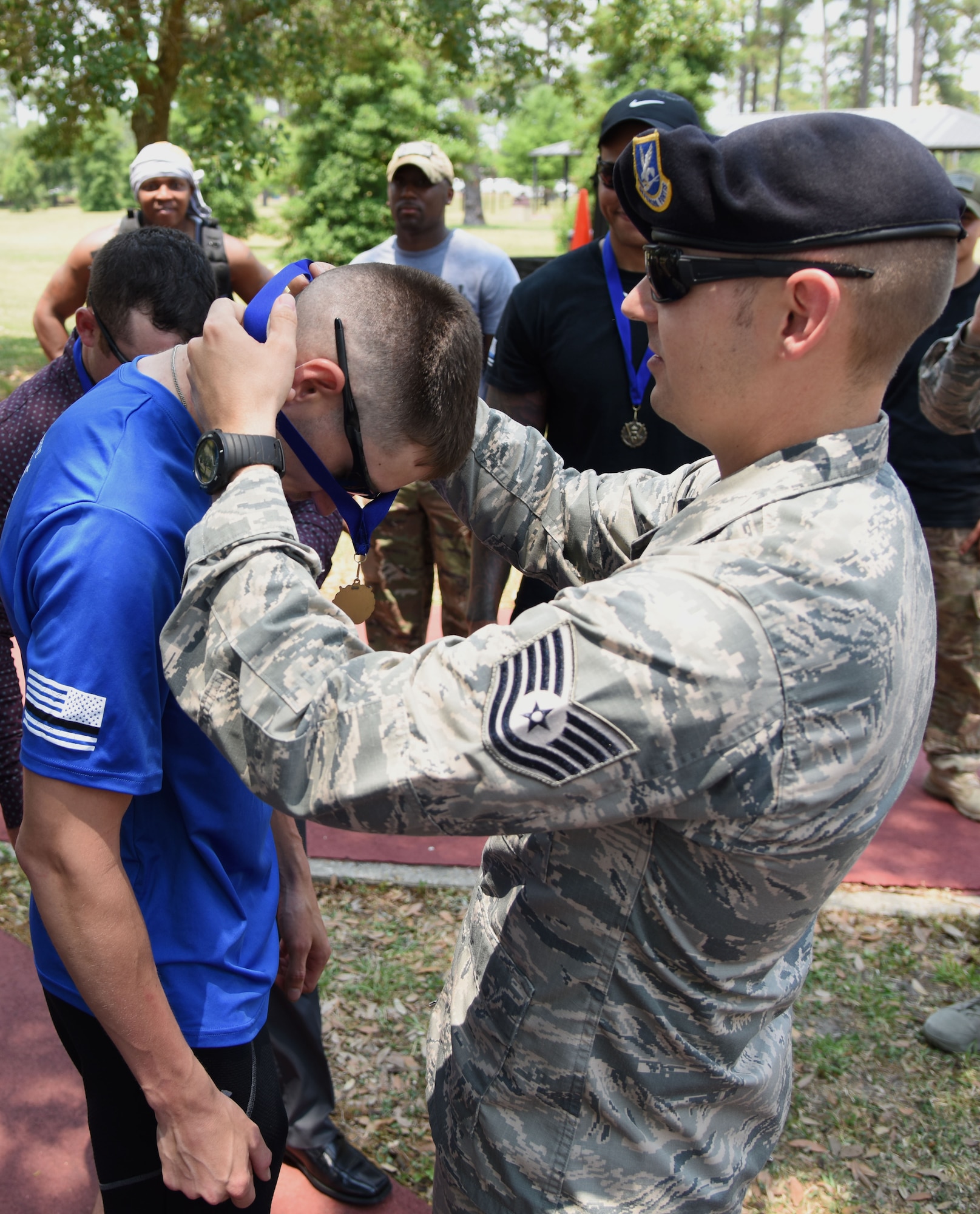 U.S. Air Force Tech. Sgt. Jonathan Talley, 81st Security Forces Squadron installation security NCO in charge, presents a medal to Staff Sgt. Danny Jackson, 81st SFS plans NCO in charge, during the 81st SFS 5K Fallen Defender Ruck and Obstacle Course competition at the Crotwell Track at Keesler Air Force Base, Mississippi, May 15, 2018. The event was held during National Police Week, which recognizes the service of law enforcement men and women who put their lives at risk every day. (U.S. Air Force photo by Kemberly Groue)