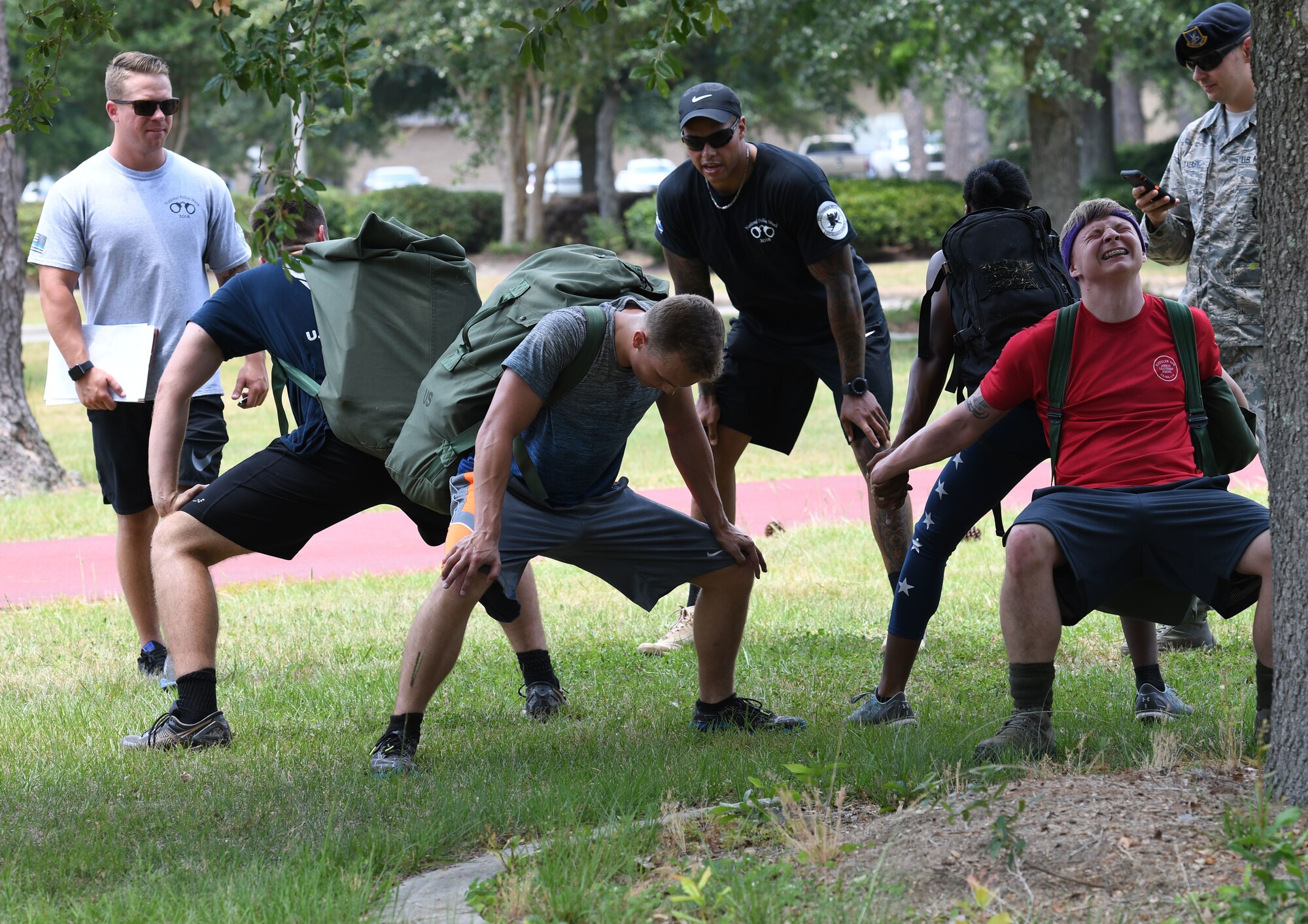 Members of the 81st Communications Squadron team participate in partner squats during the 81st Security Forces Squadron 5K Fallen Defender Ruck and Obstacle Course competition at the Crotwell Track at Keesler Air Force Base, Mississippi, May 15, 2018. The event was held during National Police Week, which recognizes the service of law enforcement men and women who put their lives at risk every day. (U.S. Air Force photo by Kemberly Groue)