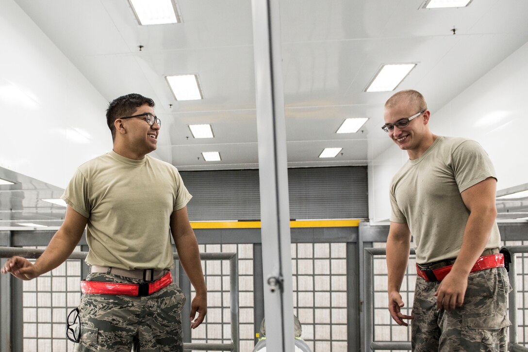 U.S. Airmen assigned to the 20th Equipment Maintenance Squadron corrosion control section laugh as they prepare an aircraft for decals at Shaw Air Force Base, S.C., May 16, 2018.