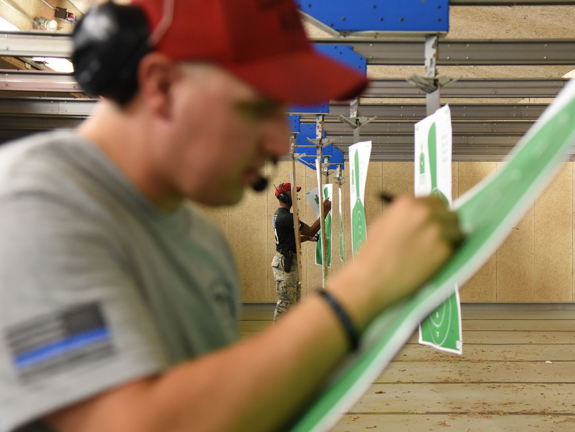 U.S. Air Force Staff Sgt. Derek Gioia, left, and Thane Sandy, 81st Security Forces Squadron combat arms instructors, calculates target scores during the 81st SFS law enforcement team competition shoot in the indoor firing range at Keesler Air Force Base, Mississippi, May 16, 2018. The event was held during National Police Week, which recognizes the service of law enforcement men and women who put their lives at risk every day. (U.S. Air Force photo by Kemberly Groue)