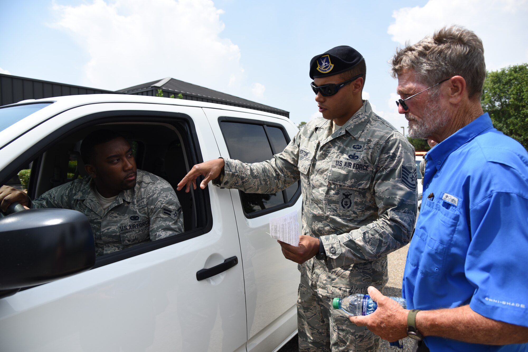 U.S. Air Force Tech. Sgt. Anthony Horton, 81st Security Forces Squadron flight chief, and Airman 1st Class Keshaun Survine, 81st SFS base defense operations center controller, provide a traffic violation demonstration for Brad Bordes, grandfather of Airman Noah Hill, 81st SFS entry controller, during the 81st SFS open house at Keesler Air Force Base, Mississippi, May 17, 2018. The open house allowed individuals to walk through a day in the life of a defender. The event was held during National Police Week, which recognizes the service of law enforcement men and women who put their lives at risk every day. (U.S. Air Force photo by Kemberly Groue)
