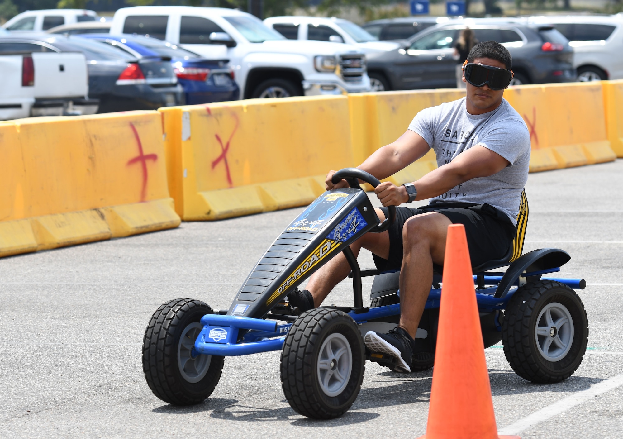 U.S. Air Force Senior Airman Bonilla Marcos, 81st Training Group training evaluator, drives a cart while wearing drunk goggles during the 81st Security Forces fun day at the base exchange at Keesler Air Force Base, Mississippi, May 18, 2018. Fun day allowed individuals to view a military working dog demonstration, a combat arms weapons stand as well as tour 81st SFS vehicles and equipment. The event was held during National Police Week, which recognizes the service of law enforcement men and women who put their lives at risk every day. (U.S. Air Force photo by Kemberly Groue)