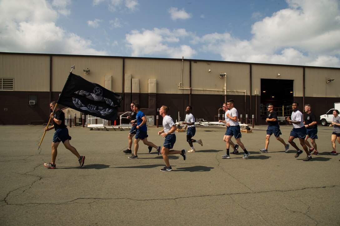 Airmen from 515th Air Mobility Operations Wing run in formation during the 5th Annual Port Dawg Memorial Run at Joint Base Pearl Harbor-Hickam, Hawaii, May 18, 2018. The purpose of the run was to honor and remember fallen Port Dawgs, Airmen who lost their lives in the air transportation career field. (Photo by Tech. Sgt. Heather Redman)