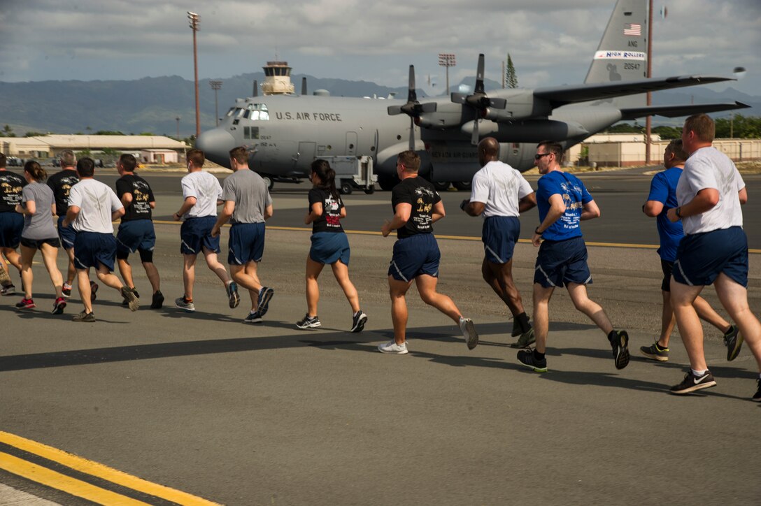 Airmen from 515th Air Mobility Operations Wing run in formation during the 5th Annual Port Dawg Memorial Run at Joint Base Pearl Harbor-Hickam, Hawaii, May 18, 2018. The purpose of the run was to honor and remember fallen Port Dawgs, Airmen who lost their lives in the air transportation career field. (Photo by Tech. Sgt. Heather Redman)
