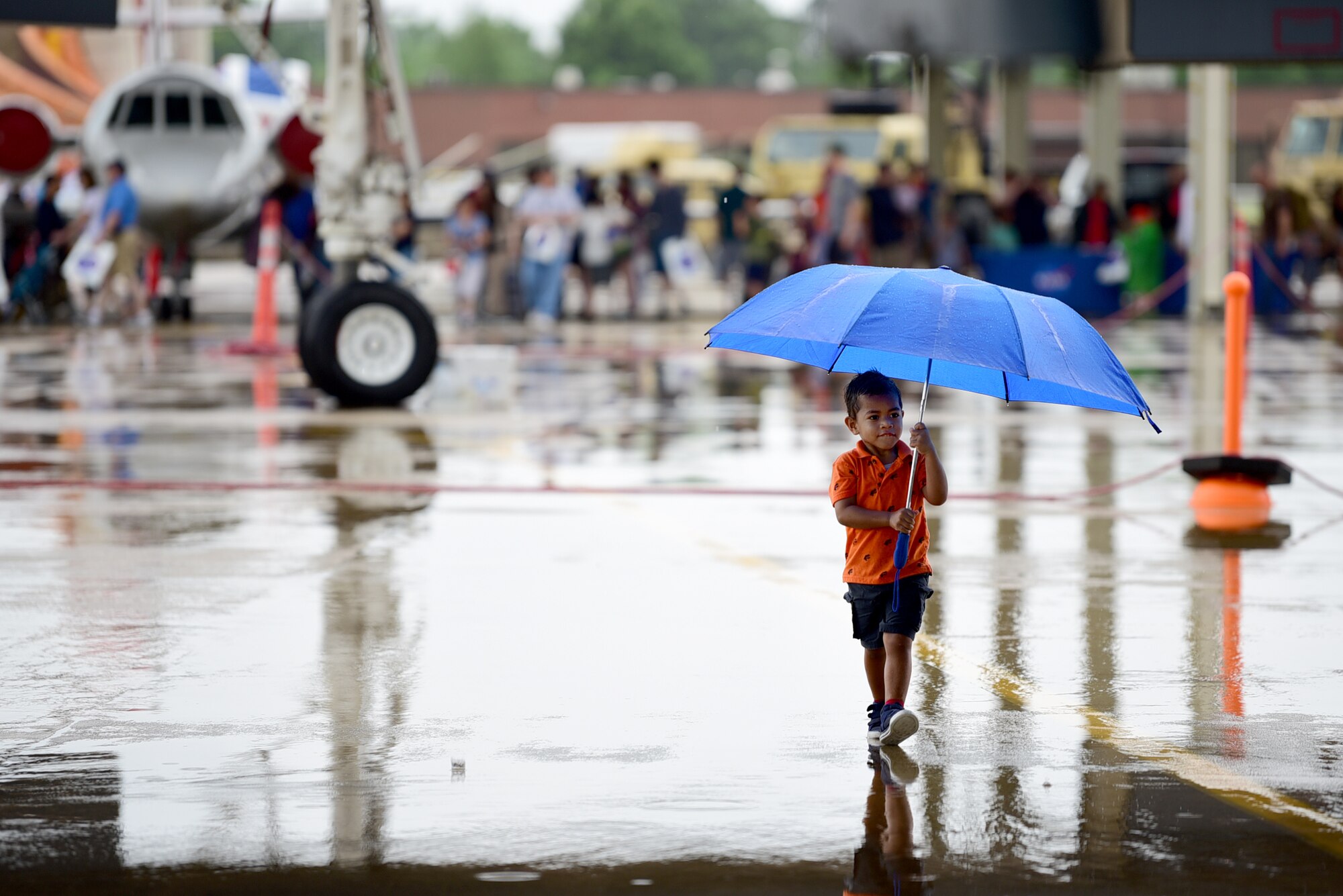 A child walks with umbrella in hand toward the MQ-9 Reaper at Joint Base Langley-Eustis, Virginia, May 19, 2018. The MQ-9 Display gathered the attention of aviation enthusiasts of all ages over the weekend for the Airpower Over Hampton Roads air show. (U.S. Air Force photo by Airman 1st Class Haley Stevens)