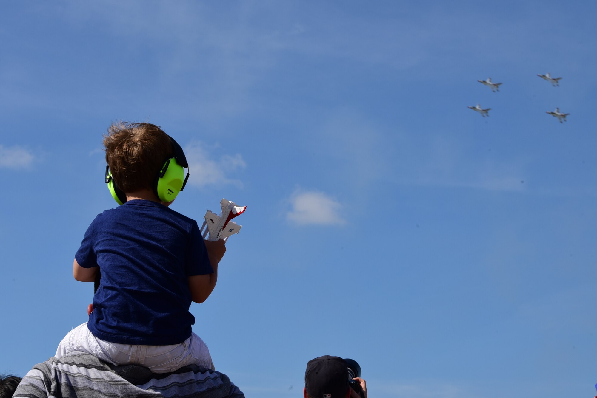 A child watches the U.S. Air Force Thunderbirds air demonstration team perform during the Airpower Over Hampton Roads air show at Joint Base Langley-Eustis, Virginia, May 20, 2018. This performance marked the first Thunderbirds demonstration since the start of this air show season. (U.S. Air Force photo by Airman 1st Class Haley Stevens)