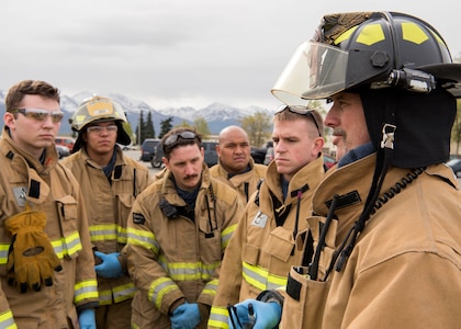 Louis Larousse, 673d Civil Engineer Squadron (CES) fire and emergency services crew chief, speaks to a small group of Airmen firefighters regarding an active-shooter exercise at Joint Base Elmendorf-Richardson, Alaska, May 17, 2018. Airmen from the Alaska Air National Guard’s 176th Wing and the 673d CES fire and emergency services participated in an exercise in preparations for the Arctic Thunder Open House scheduled to take place June 30 and July 1. The exercise tests their capabilities in challenging circumstances and provide training for possible incidents. The Airmen were given feedback and an opportunity to learn from the scenario at the end of the exercise.