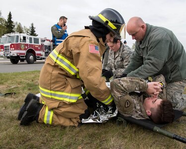 Airman 1st Class Brittney Jordan, 673d Civil Engineer Squadron (CES) firefighter, covers a simulated victim with an emergency blanket during an active-shooter exercise at Joint Base Elmendorf-Richardson, Alaska, May 17, 2018. The 673d CES fire and emergency services participated in an exercise in preparations for the Arctic Thunder Open House scheduled to take place June 30 and July 1. The exercise is used to test their capabilities in challenging circumstances and provide training for possible incidents and provide support to medical personnel throughout the scenario.