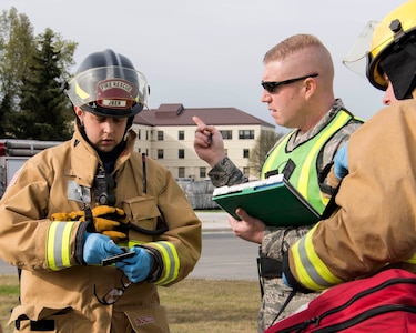 Airman 1st Class Alec Cagle, a 673d Civil Engineer Squadron (CES) firefighter, speaks with Tech. Sgt. Matthew Keenan, a 673d CES safety officer, during an active-shooter exercise at Joint Base Elmendorf-Richardson, Alaska, May 17, 2018. The 673d CES participated in an exercise in preparations for the Arctic Thunder Open House scheduled to take place June 30 and July 1. The exercise is used to test their capabilities in challenging circumstances and provide training for possible incidents.