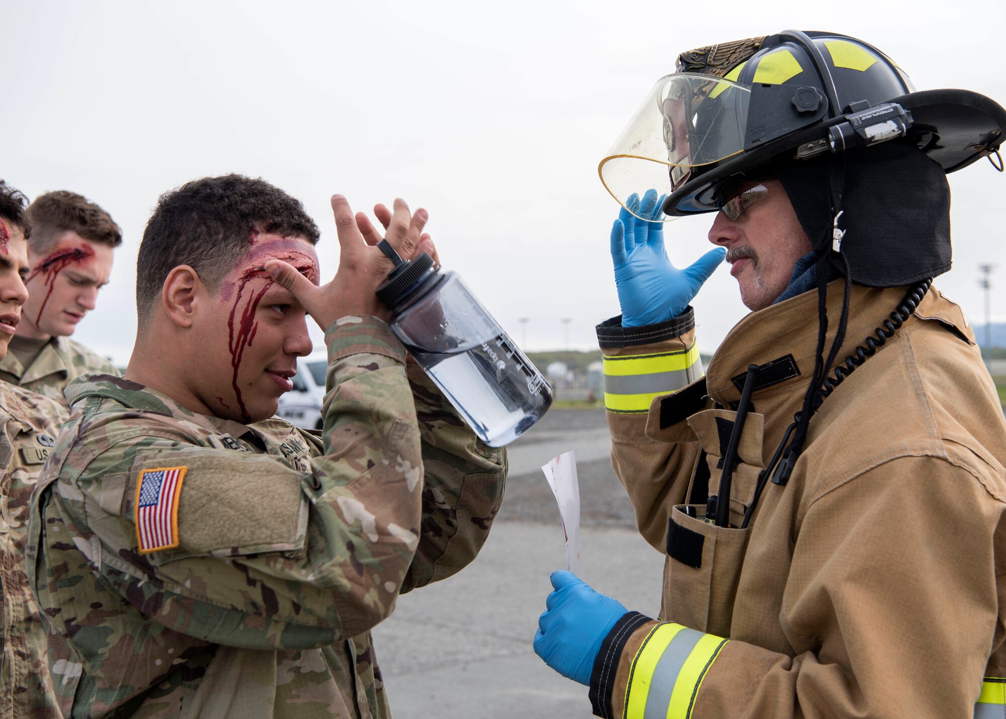 Louis Larousse, 673d Civil Engineer Squadron (CES) fire emergency services crew chief, speaks to a small group of Soldiers acting as victims during the active-shooter exercise at Joint Base Elmendorf-Richardson, Alaska, May 17, 2018. Larousse is a crew chief on Fire Engine #2 and was a lead participant in the exercise in preparations for the Arctic Thunder Open House scheduled to take place June 30 and July 1. This exercise provided a scenario and specific training on possible threats. The Airmen were given feedback and an opportunity to learn from the scenario at the end of the exercise.