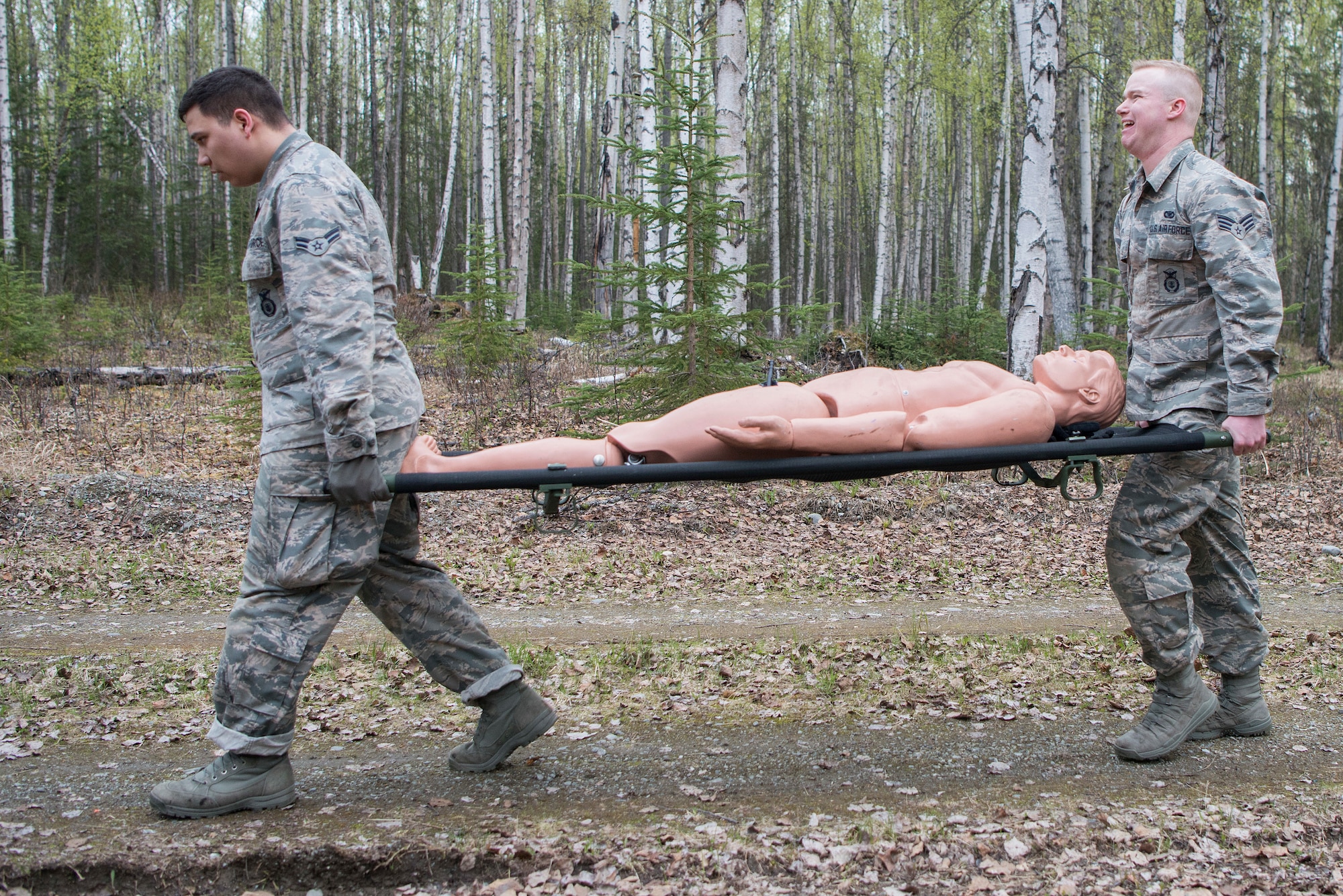 Members of the 673d Security Forces Squadron carry a litter to the forward operating base training station at the Defenders Day Challenge during Police Week on Joint Base Elmendorf-Richardson, Alaska, May 16, 2018. Carrying the litter to the FOB is a part of Tactical Combat Casualty Care. TCCC involves three stages; care under fire, tactical field care, and tactical evacuation care.