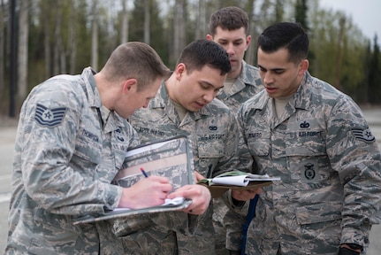 Air Force Tech. Sgt. Michael Thompson, 673d Security Forces Squadron operations support noncommissioned officer in charge, assesses a team’s reading of a 9-line MEDEVAC call, at the Defenders Day Challenge on Joint Base Elmendorf-Richardson, Alaska, May 16, 2018. The 9-line MEDEVAC call consists of stating information such as location, patient status, security, radio frequency and more.