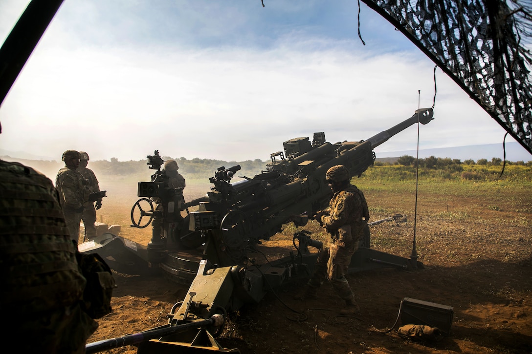 Soldiers prepare to fire an M777 howitzer.