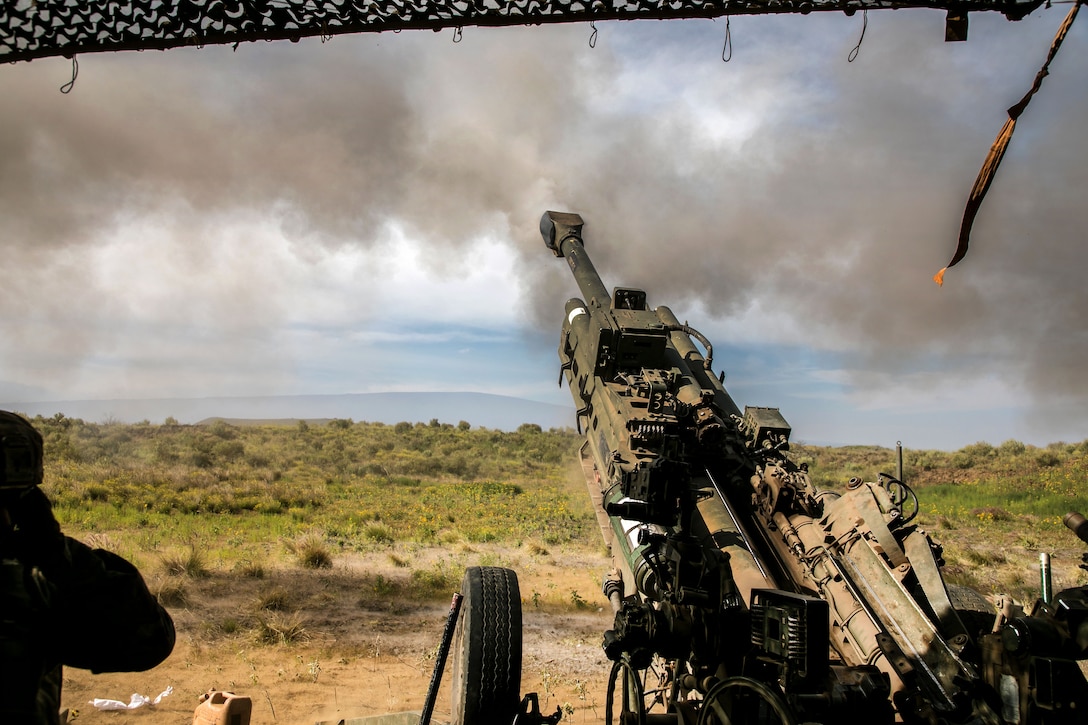 Soldiers fire an M777 howitzer during a fire mission.