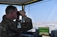 Airman looks through binoculars in tower