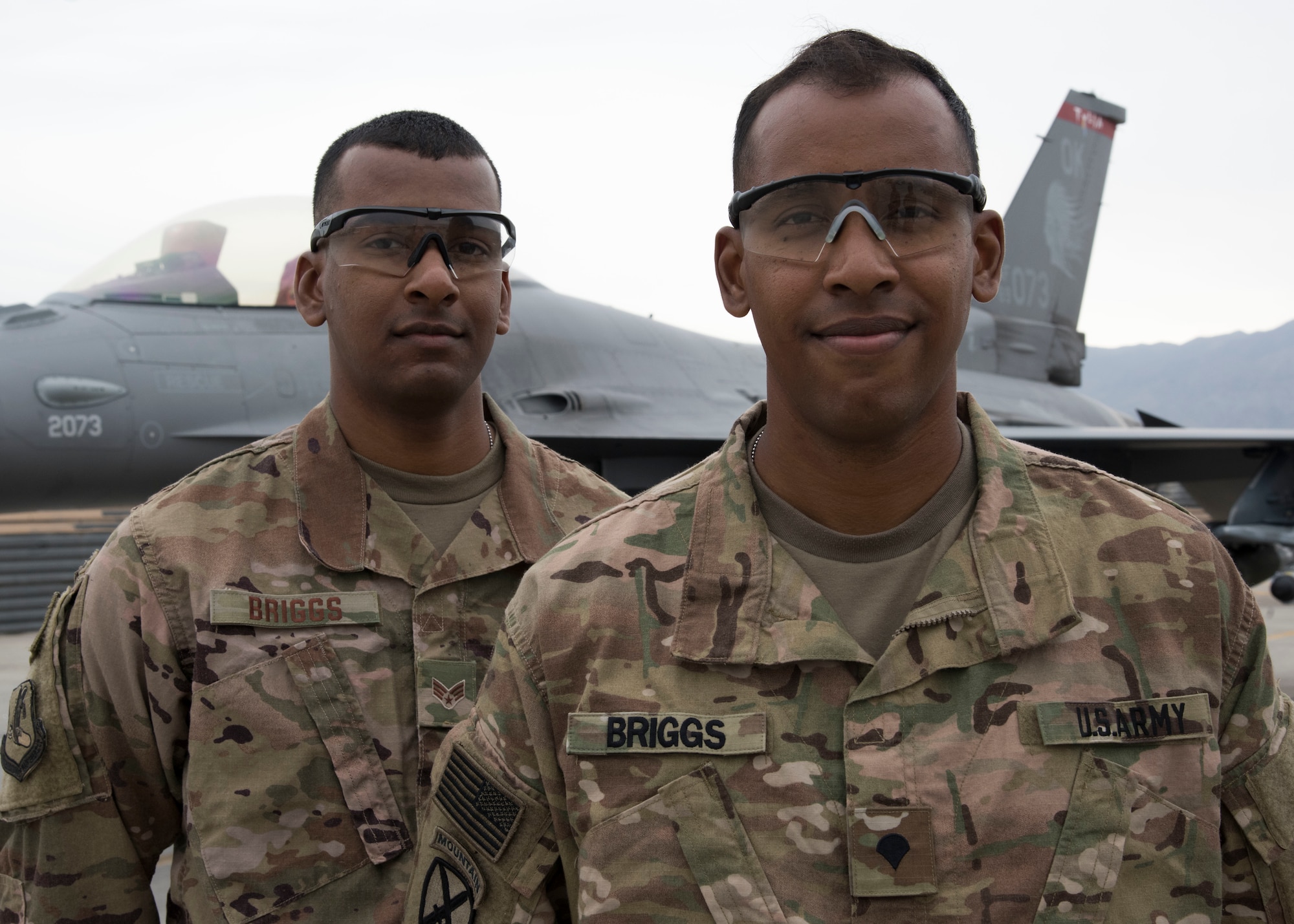 Senior Airman Elliot Briggs (left), a maintenance analyst technician with the 455th Expeditionary Maintenance Group, and Spc. Leon Briggs, a vehicle mechanic with the 1-87th Infantry Battalion, 10th Mountain Infantry Division, pose for a photo at Bagram Airfield, Afghanistan, May 12. The deployment to Afghanistan is the first time the two brothers have been deployed to the same location since enlisting. (U.S. Air Force photo/Tech. Sgt. Eugene Crist)