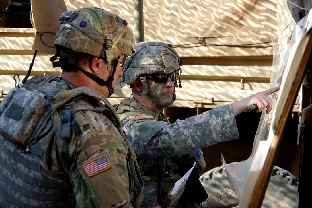 A soldier gives a mission brief to a team member.