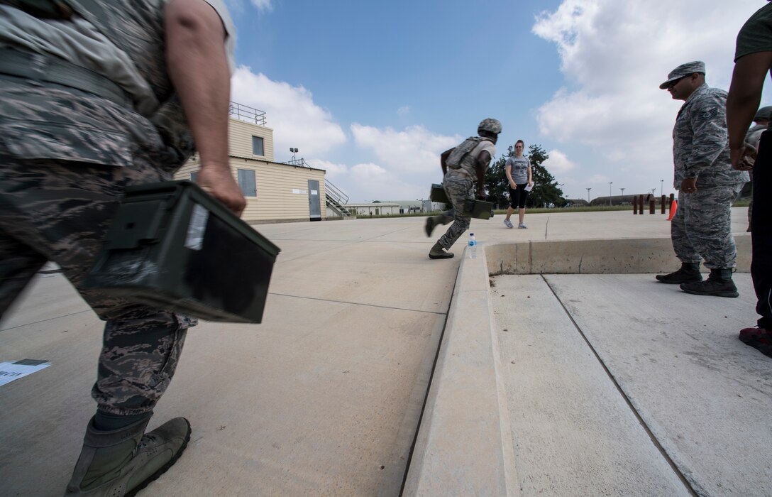 Airmen running with ammunition cans during event