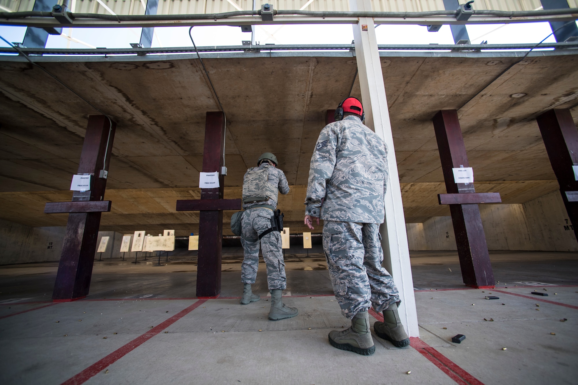 CATM Airman helps Airman shoot pistol during competition