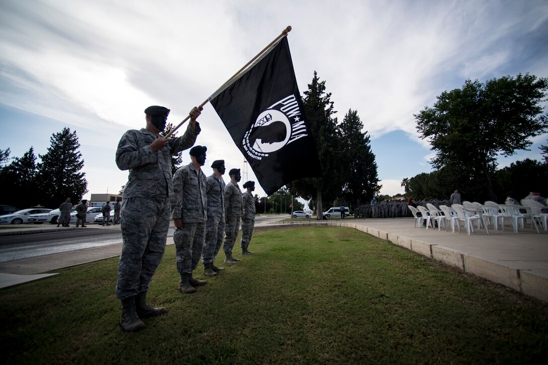Airmen hold POW/MIA flag during retreat ceremony