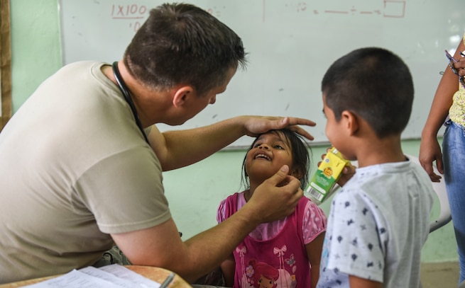 An Air Force doctor examines a child in Panama.