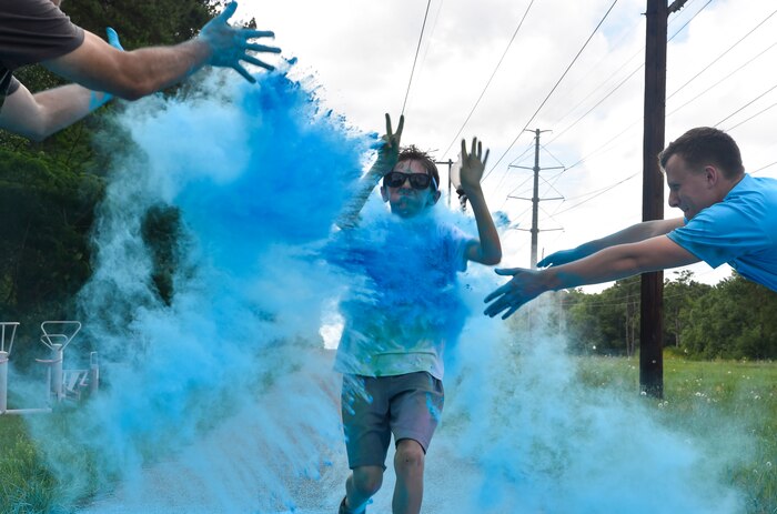 A child from the Joint Base Charleston Youth Center runs through colored chalk during a color run May 18, 2018, at JB Charleston, S.C.
