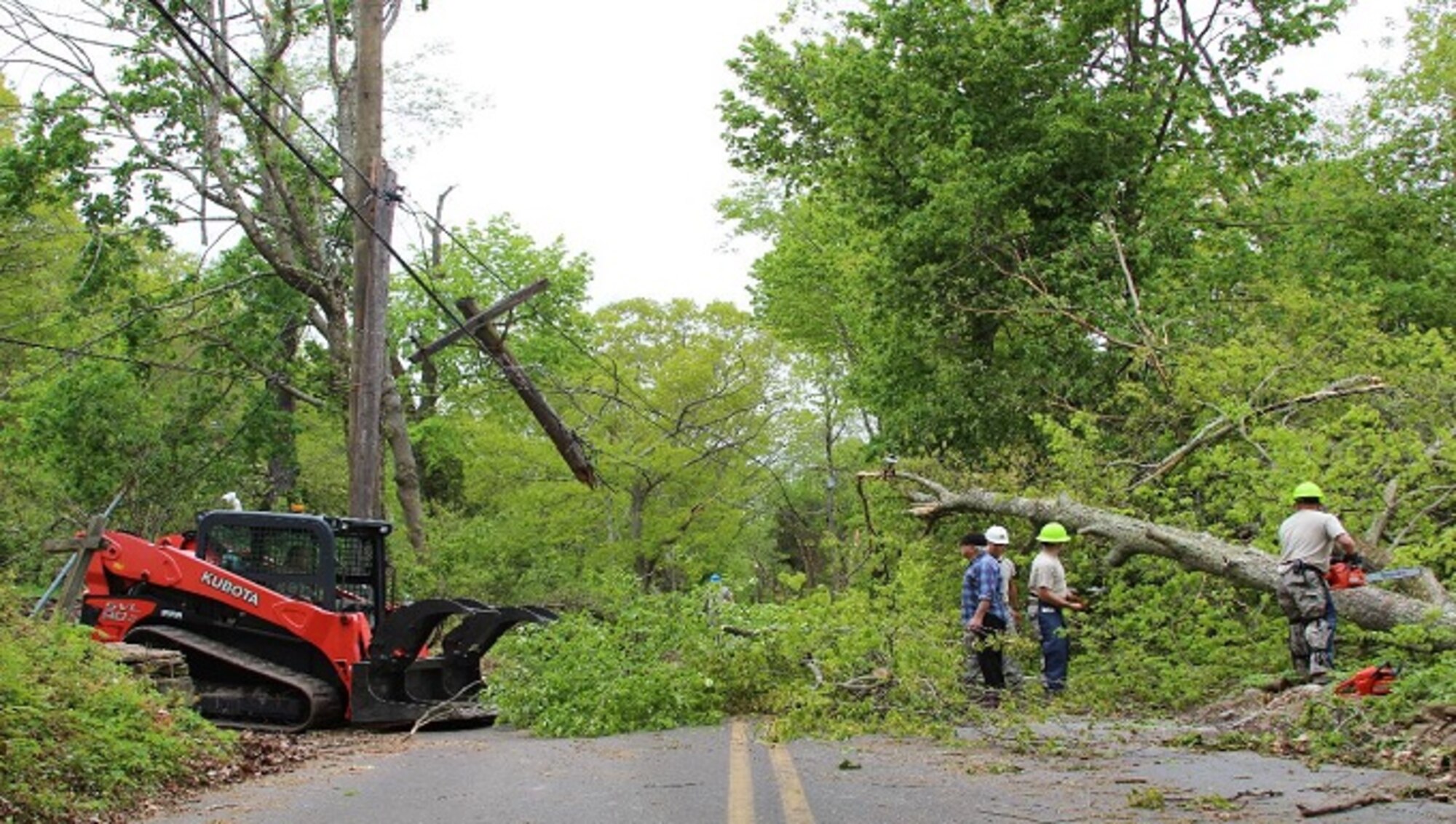 A resident surveys the road clearing progress by members of the 103rd Civil Engineering Squadron May 18, 2018 in Bethany, Conn. The Connecticut National Guard was activated to assist local and state to clear roads made impassable by the storm May 15, 2018. (U.S. Air National Guard photo by 1st Lt. Jen Pierce/released)